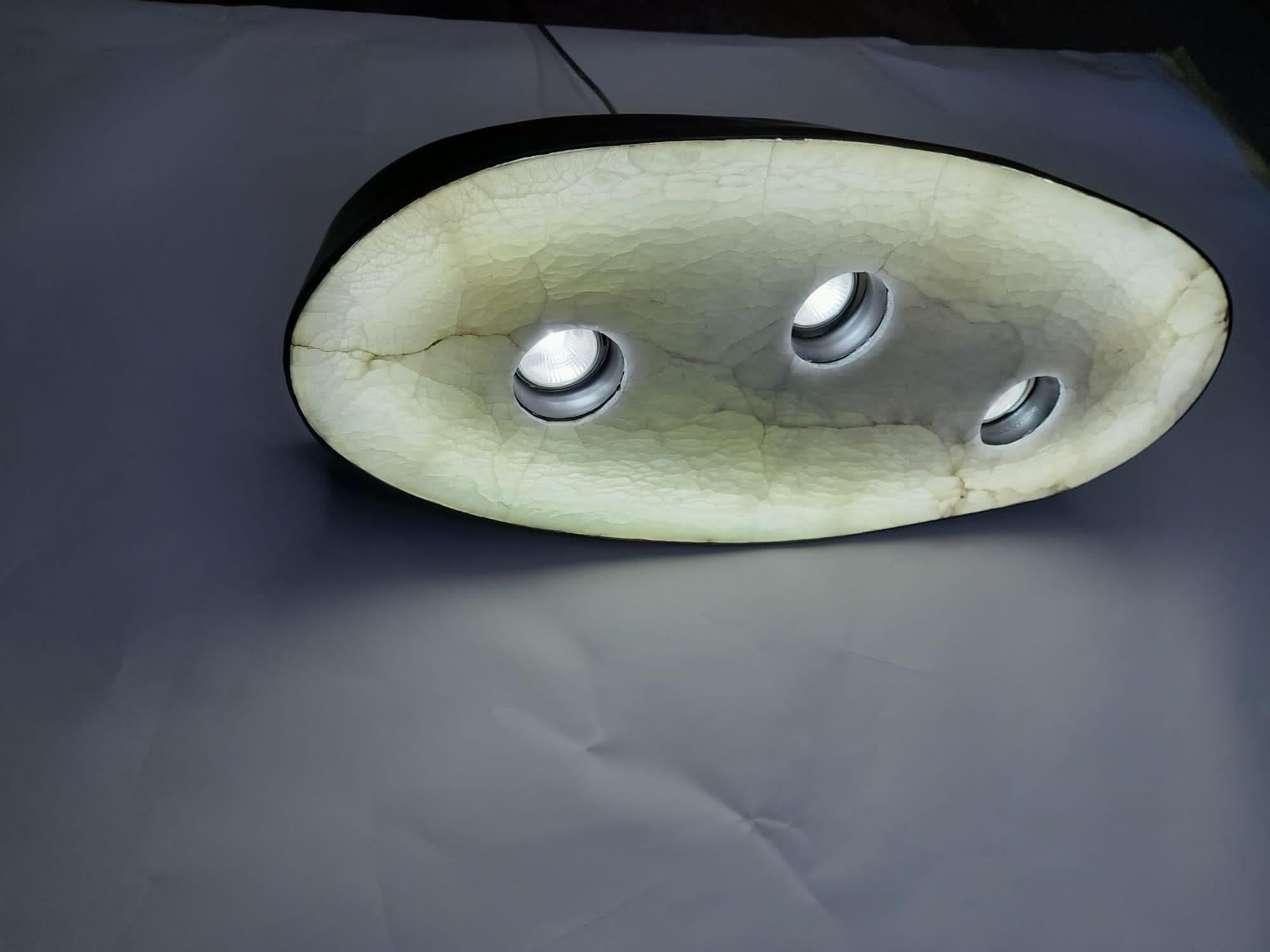 The housing of this pendant is in vivak matt black lacquered. Oval bottem in alabaster.
Inside 3 spots MR and an oval shaped TL lamp. Only possible in 220 volt. 
Gives cosy light according to color of alabaster.