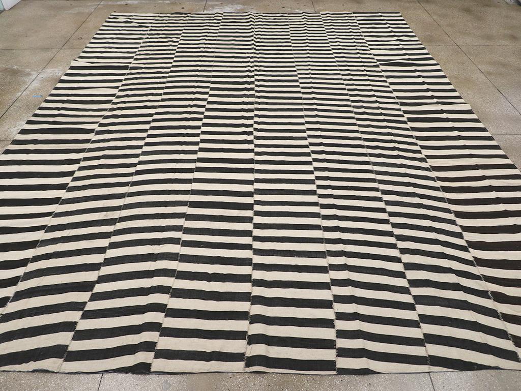 Una alfombra persa moderna de tejido plano Kilim de gran tamaño para una habitación, hecha a mano durante el siglo XXI.

Medidas: 12' 1