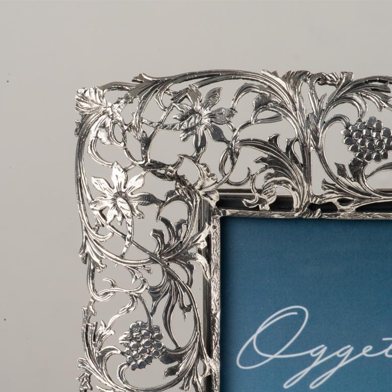 Elegante marco de bronce fundido a la cera perdida, plateado,  ideal para realzar tus recuerdos más preciados. Producto artesano italiano. El borde, ricamente decorado, presenta la libertad, creada mediante la técnica de fundición a la cera perdida.