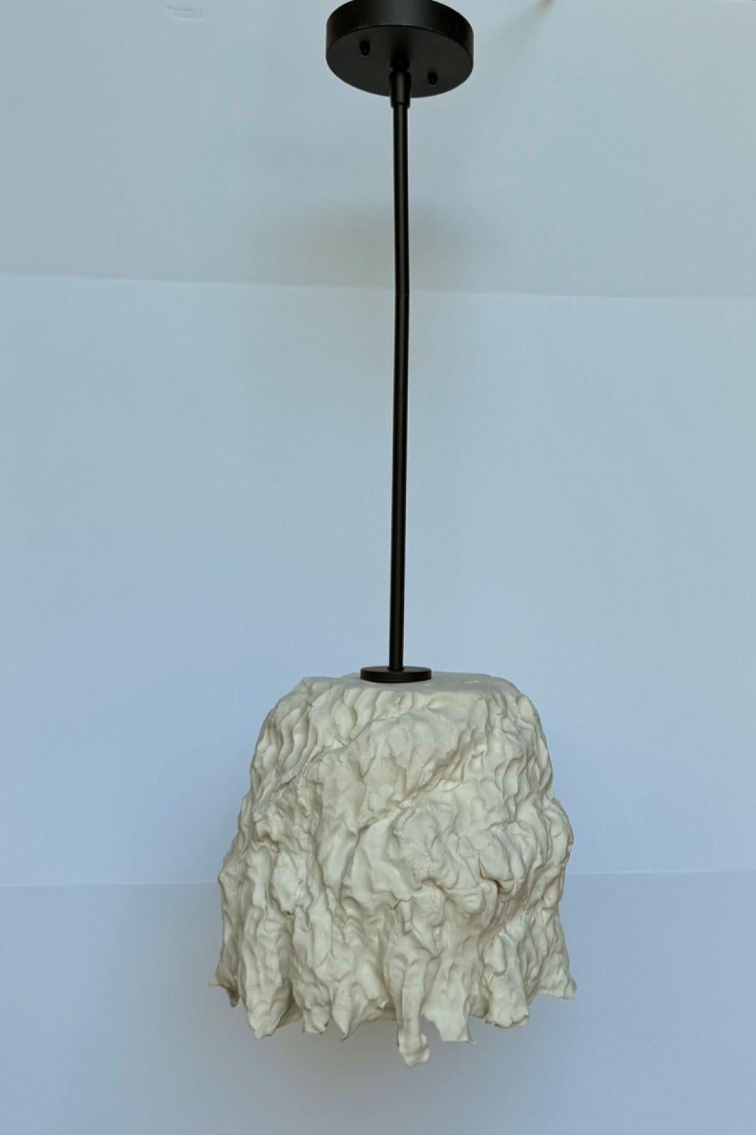 

Lampada a sospensione in porcellana realizzata a mano dall'artista americano Charles Burleigh. 

Quest'opera, cotta in biscotto e non smaltata, produce un sorprendente effetto traslucido quando viene illuminata da dietro la superficie della