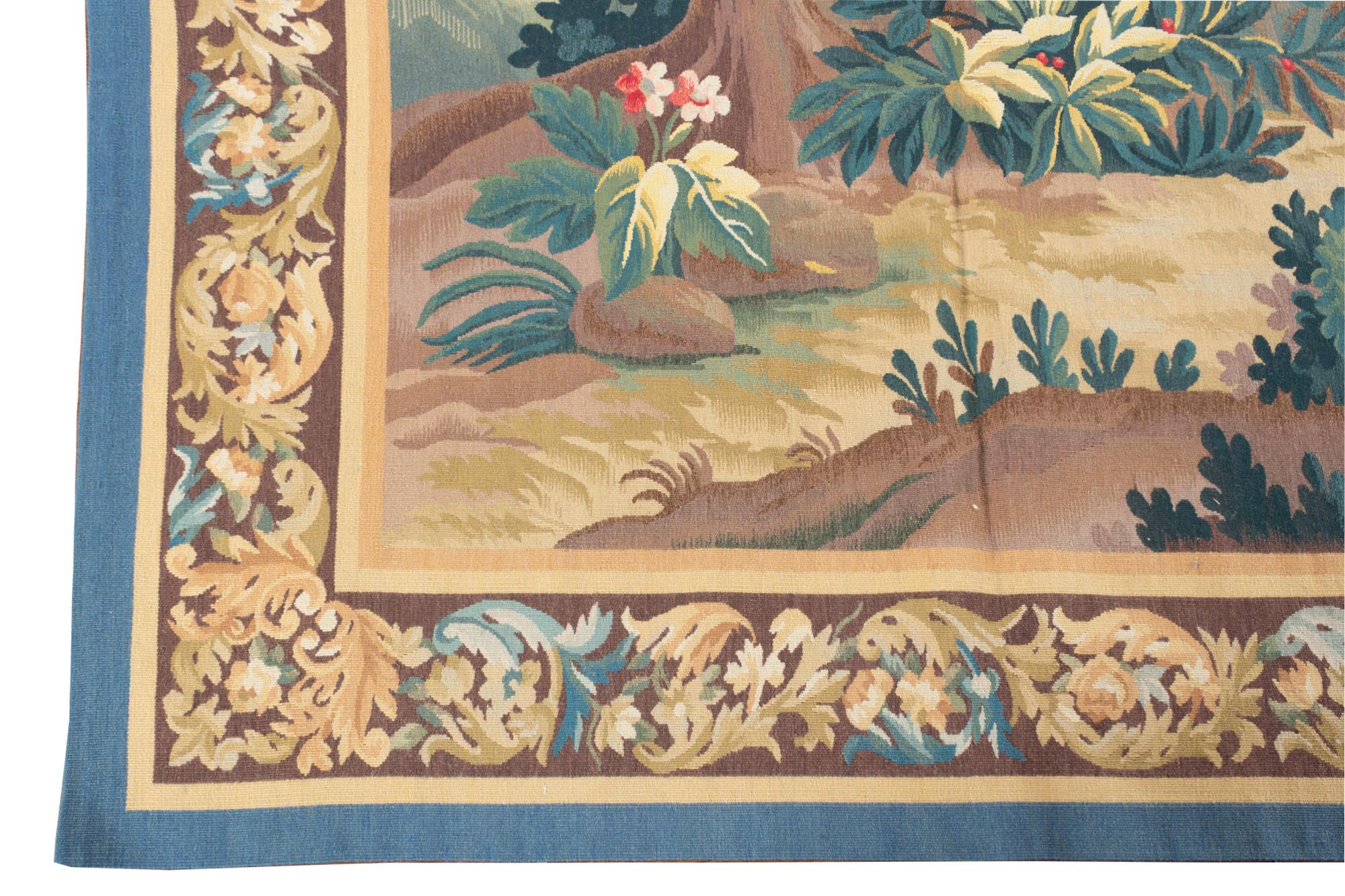 A graceful verdure style tapestry in the style of those woven in the 18th century at Aubusson, one of the chief tapestry weaving towns in 18th century France. This landscape scene is marked by the simple beauty inherent to the 18th century northern