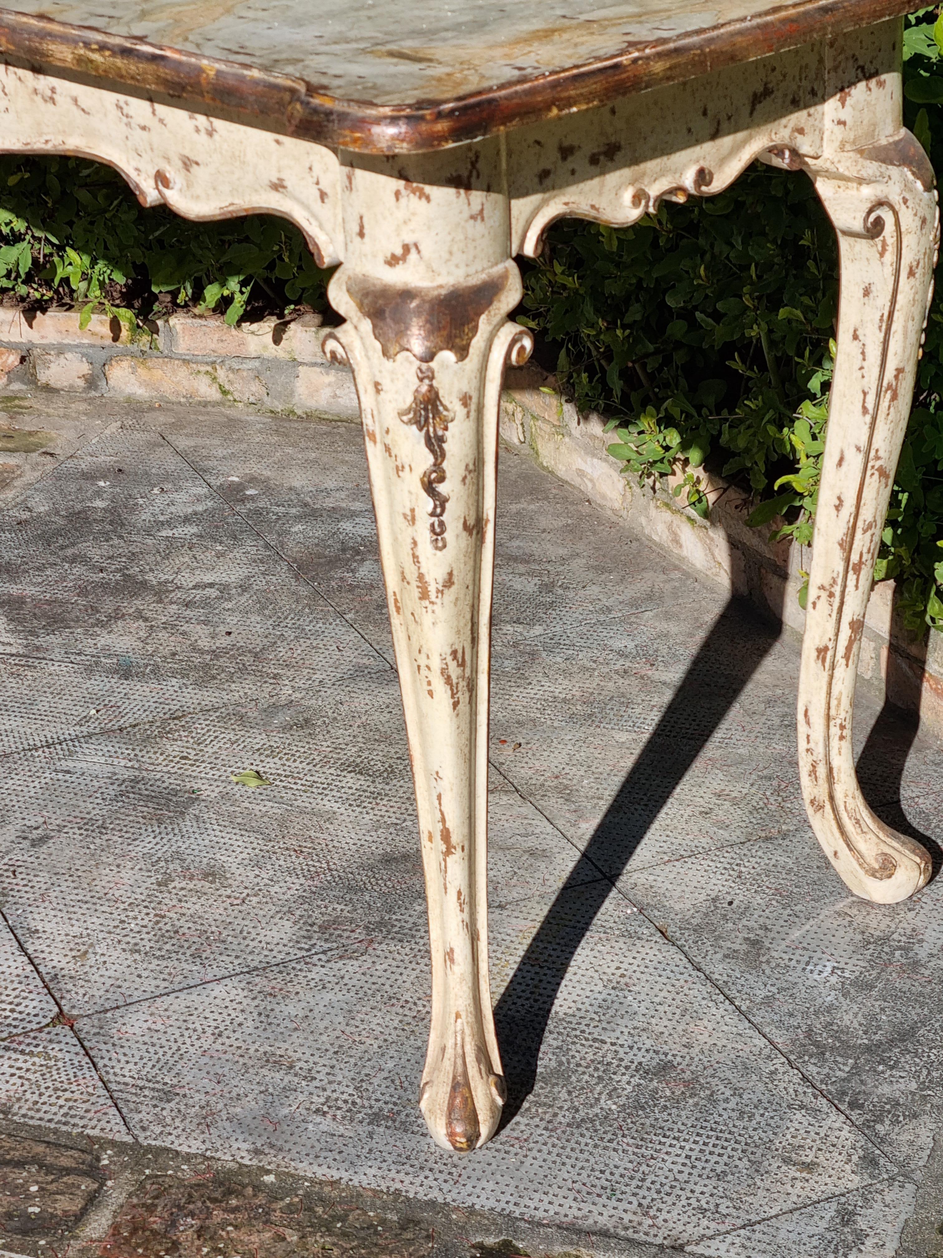 Exceptional Rococo style hand carved side table. The lacquering in antique ivory and antique silver was done by hand. On the top, the painting has an effect of faux-marbre and the whole console has been decorated in order to make an antique