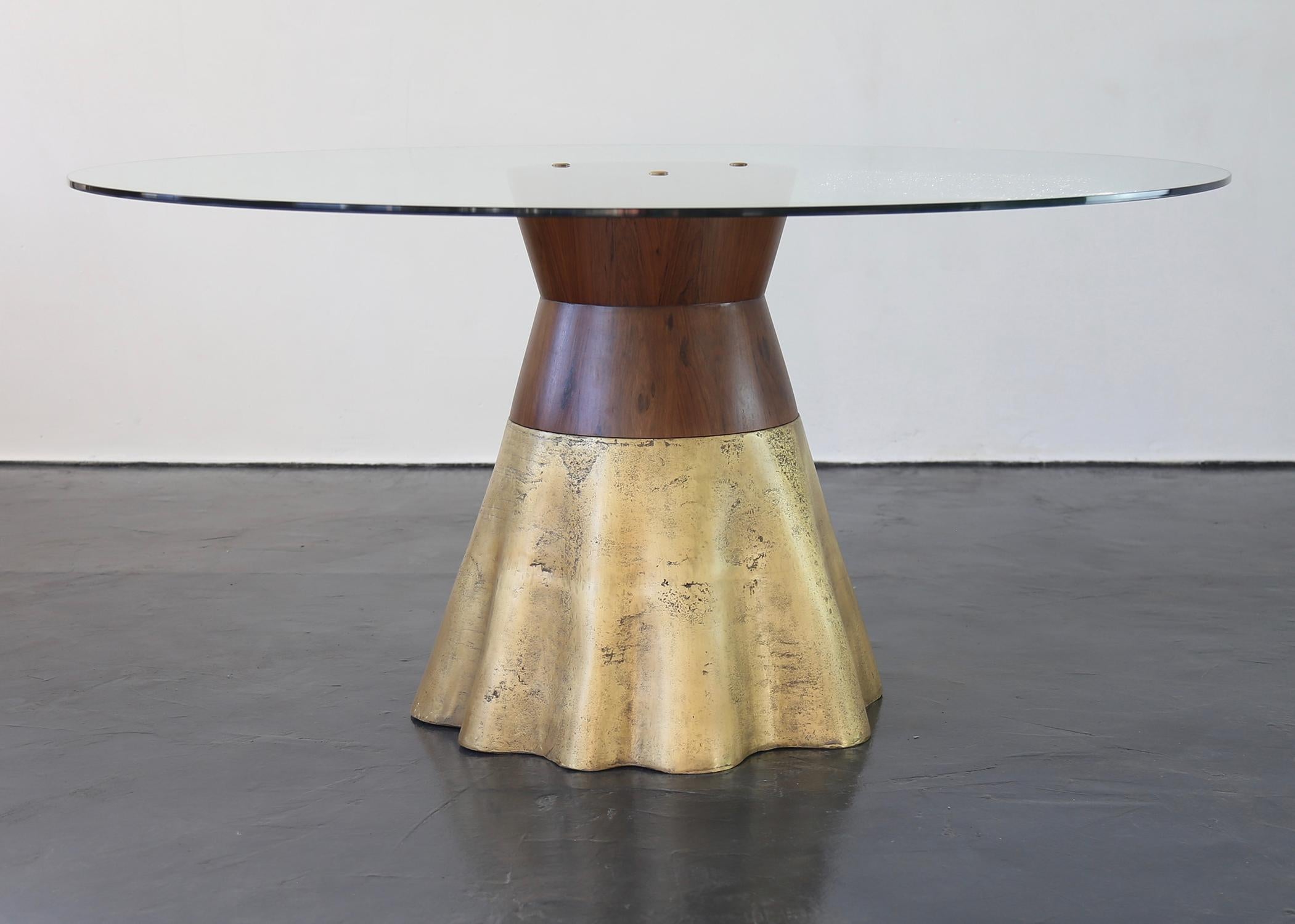The Tavola 9 debuted at the 2009 Salone del Mobile in Milans and features an organic, wavy cast bronze base joined to a rigid, conical wood support.   Only partially polished to show the evidence of the burnt earth that once surrounded the bronze,