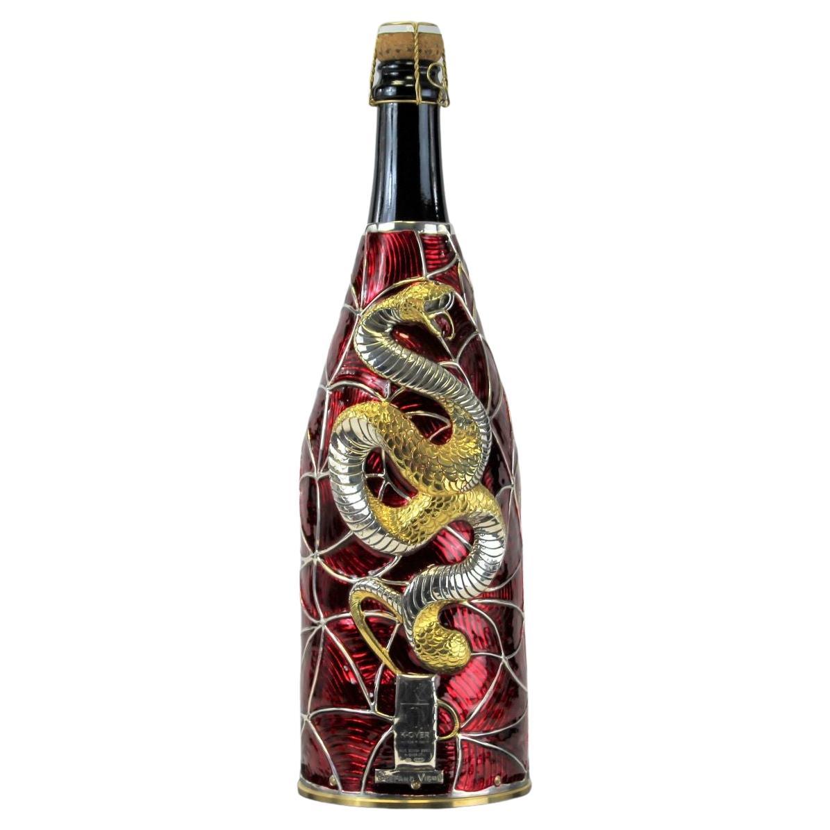This Champagne K-Over is part of our Collection Work of Art.
Completely created in pure Silver 999/°°, chiseled and painted by hand by our Artist Stefano Vigni.
The Artist designed a sinuous geometrical background where a Golden Snake takes form in