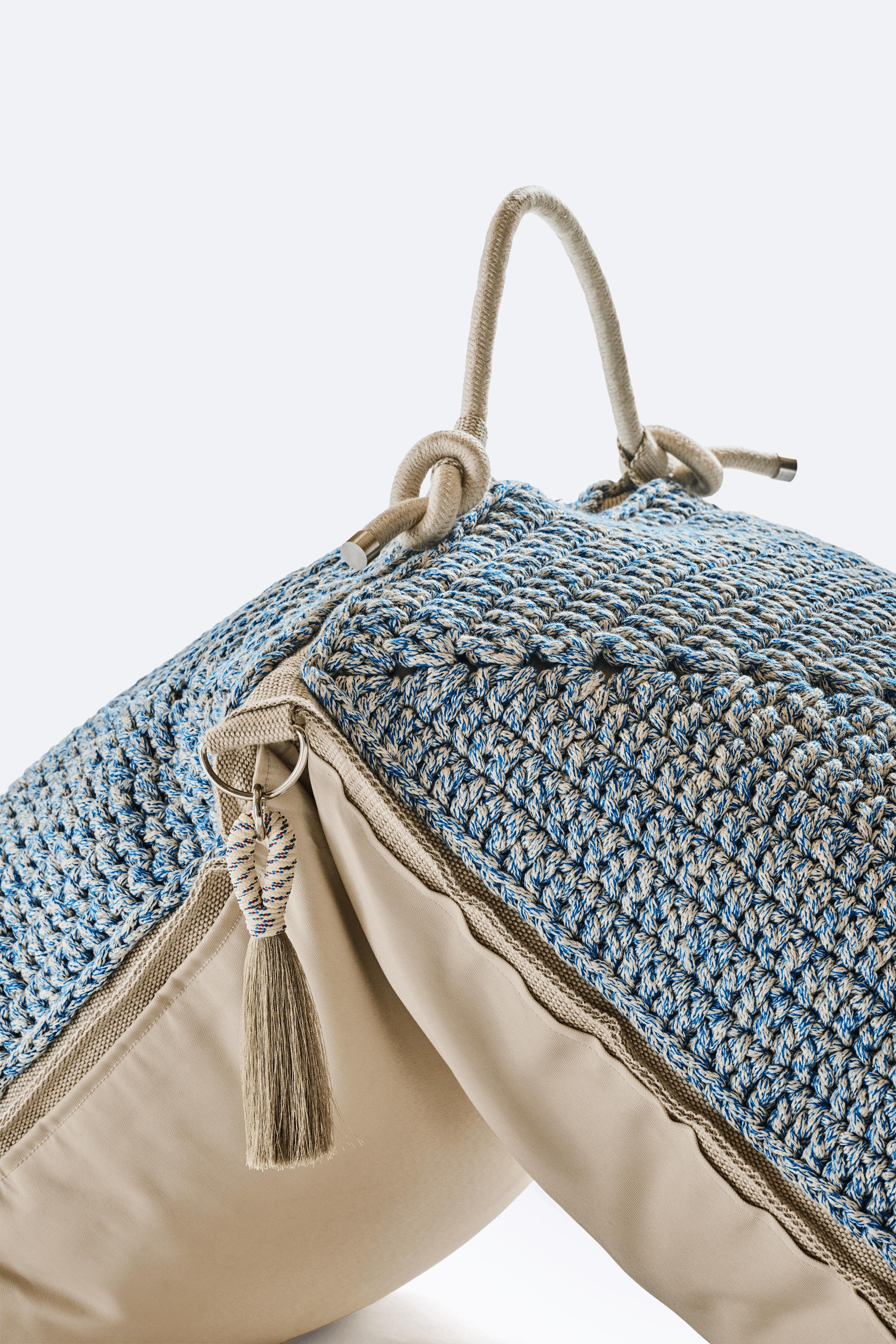 The classic crochet granny square takes a contemporary twist in this large floor cushion. Two squares form the cushion which are than sewn together with bespoke outdoor webbing. It explores the aesthetics of nomads and wants to live both inside and