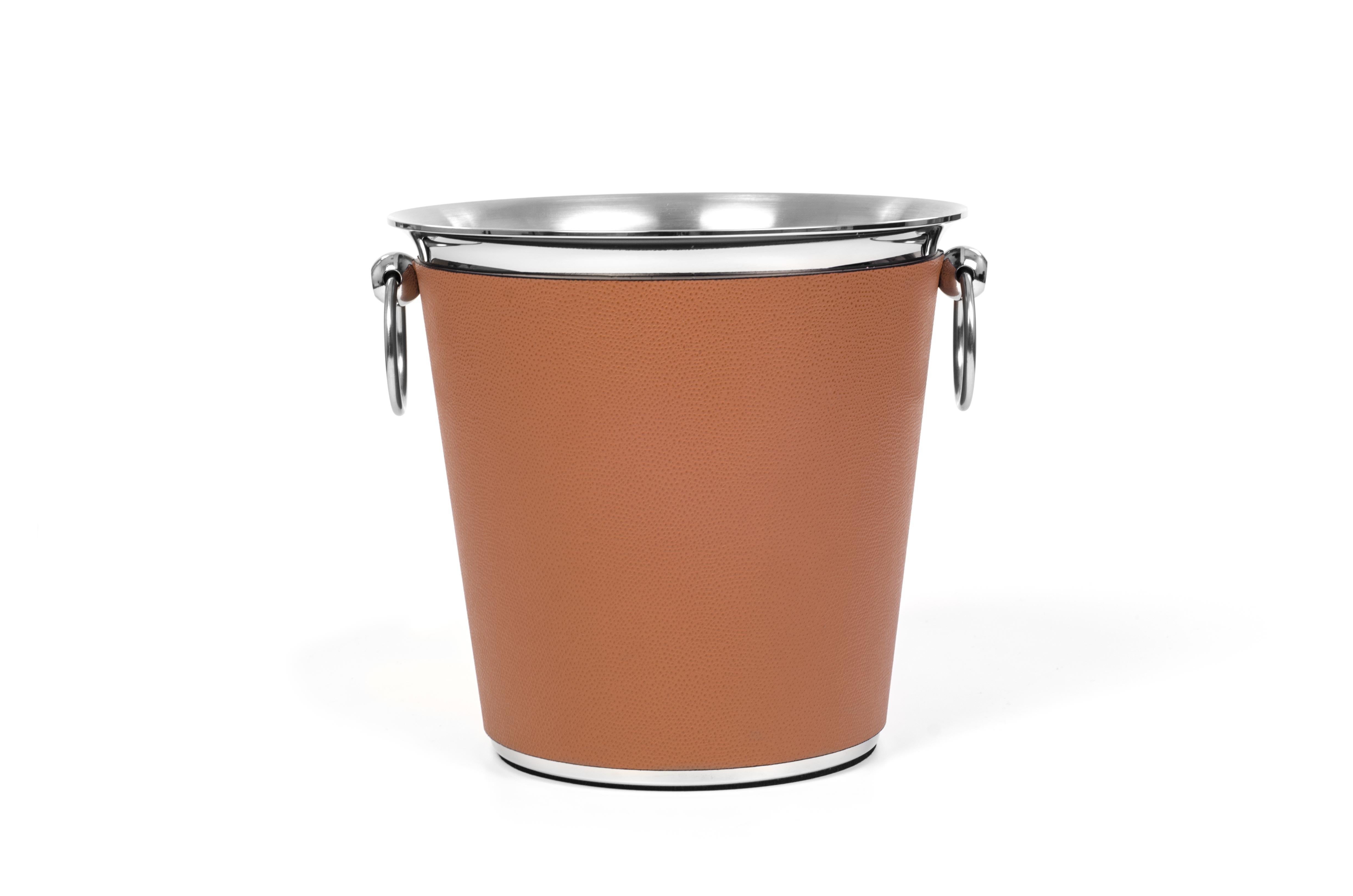A cylindrical body that delicately flares to a wide top well finished by two round handles.

The steel wine cooler with leather sleeve comes also in a generous size ideal for champagne. A must-have accessory to get your night started.