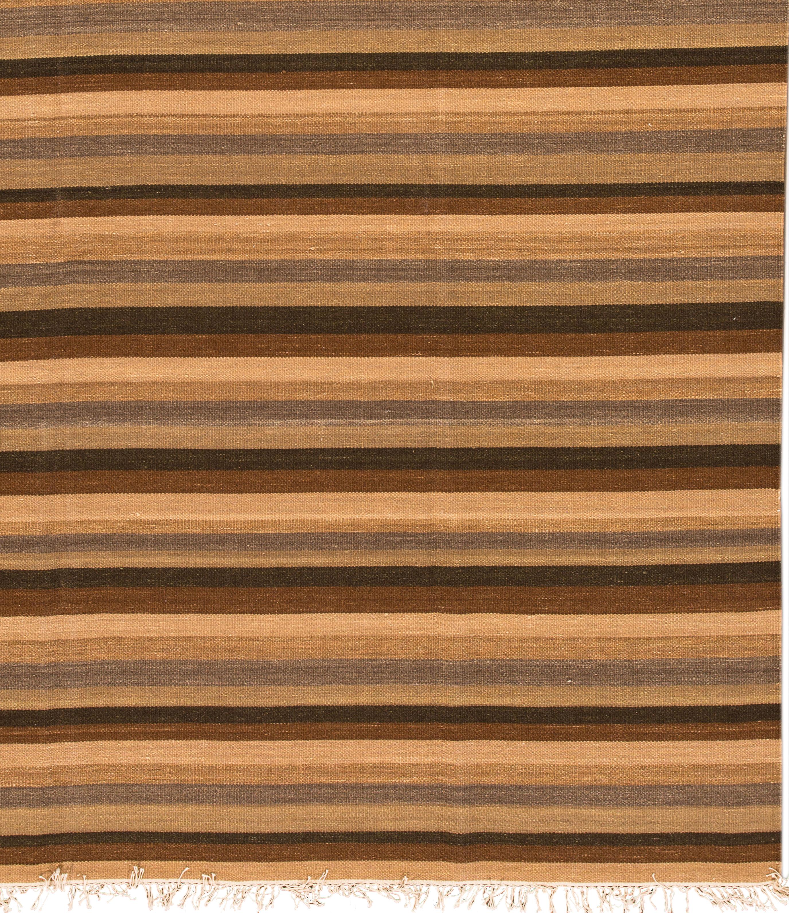 21st century Turkish Kilim rug, hand knotted wool with an all-over striped dark brown, light brown and tan field.
This rug measures 7' 10