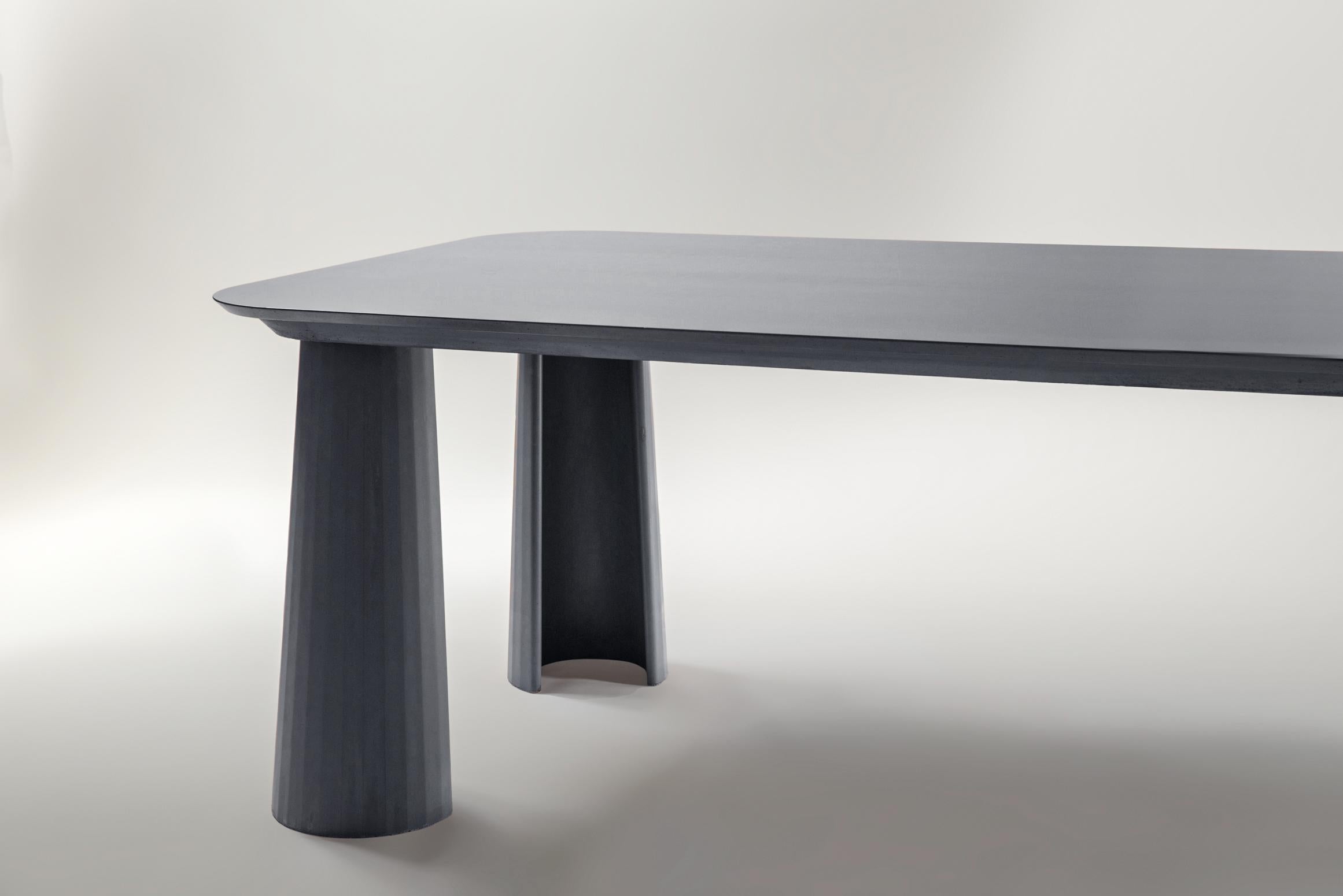 Rectangular shape dining table part of a collection of modular system in ultra-high performing cement mortar. UHPC tabletop and base colored in the mixture and sandblasted. Available in eight different colors: Brick, silver, powder, cream, fir,