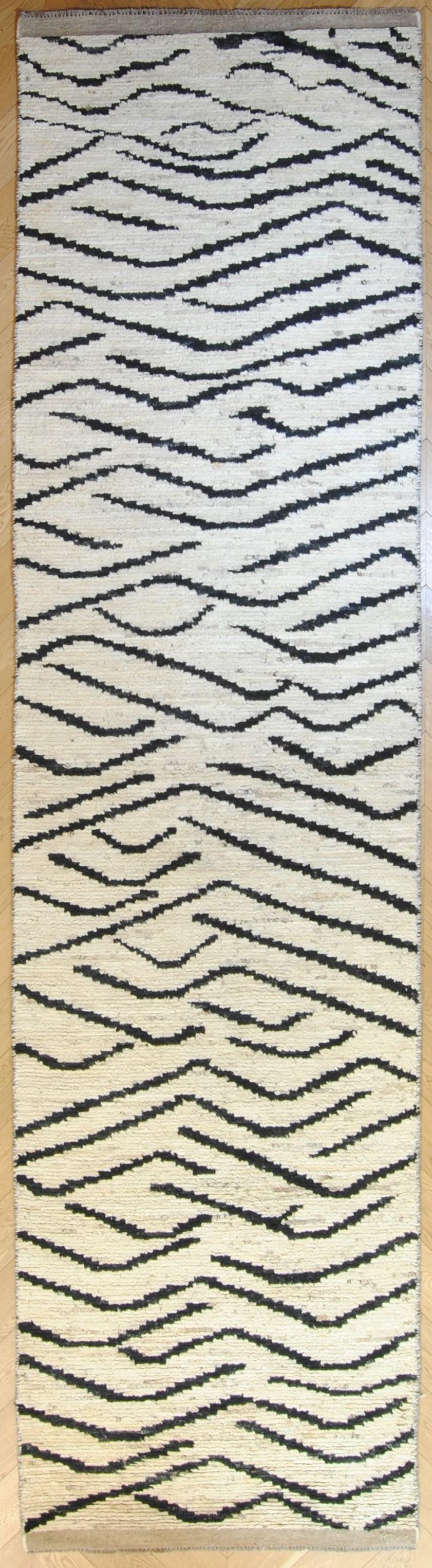 This Afghan rug is a work of contemporary art made with a technique of ancient weaving: the decoration draws inspiration from the so-called 