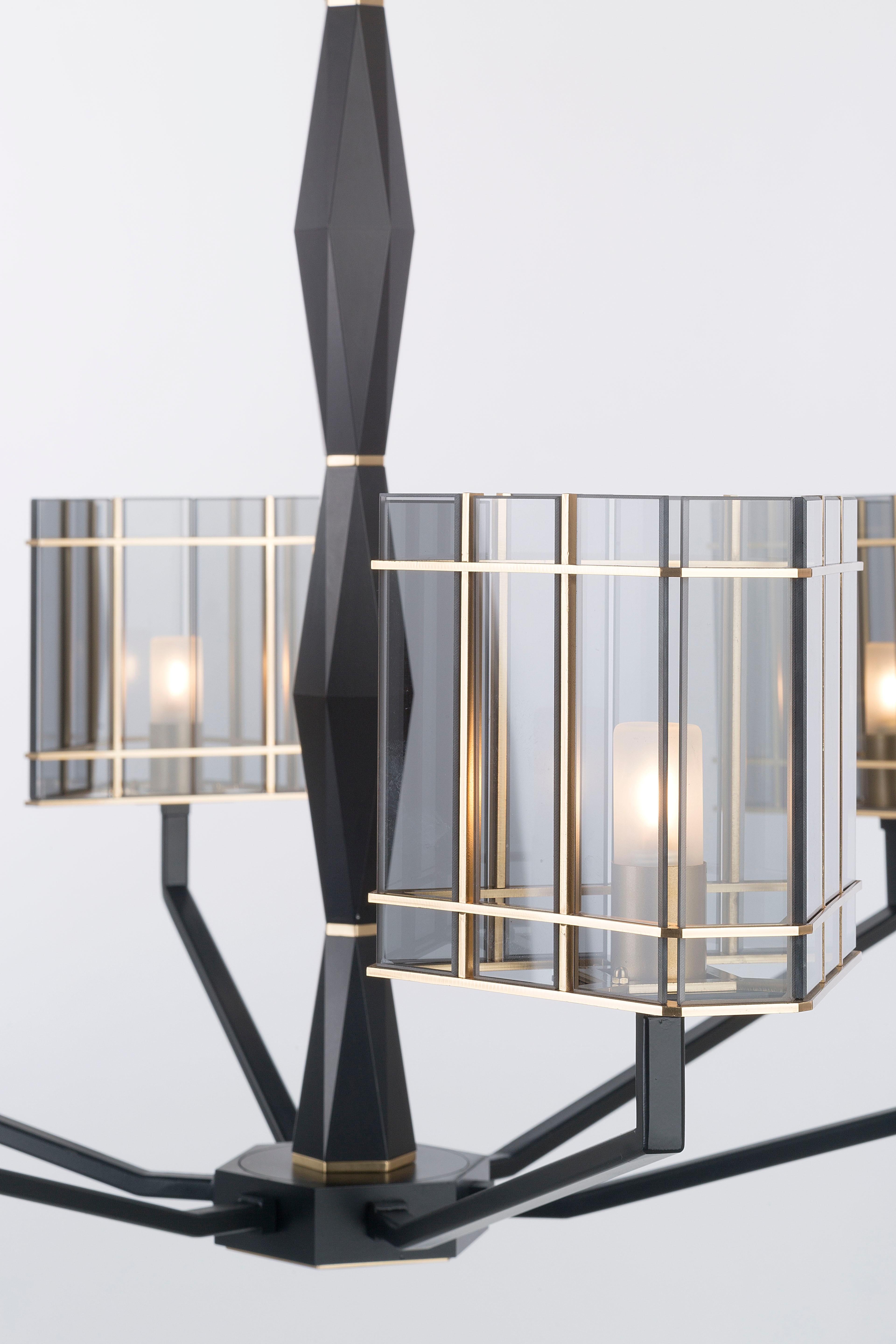 Top Glass collection, a sophisticated line where the matte black finish designs geometries on the solid faceted structure and the shades are composed of glass elements in golden cages. 

Shades in transparent glass elements in fumè color, central