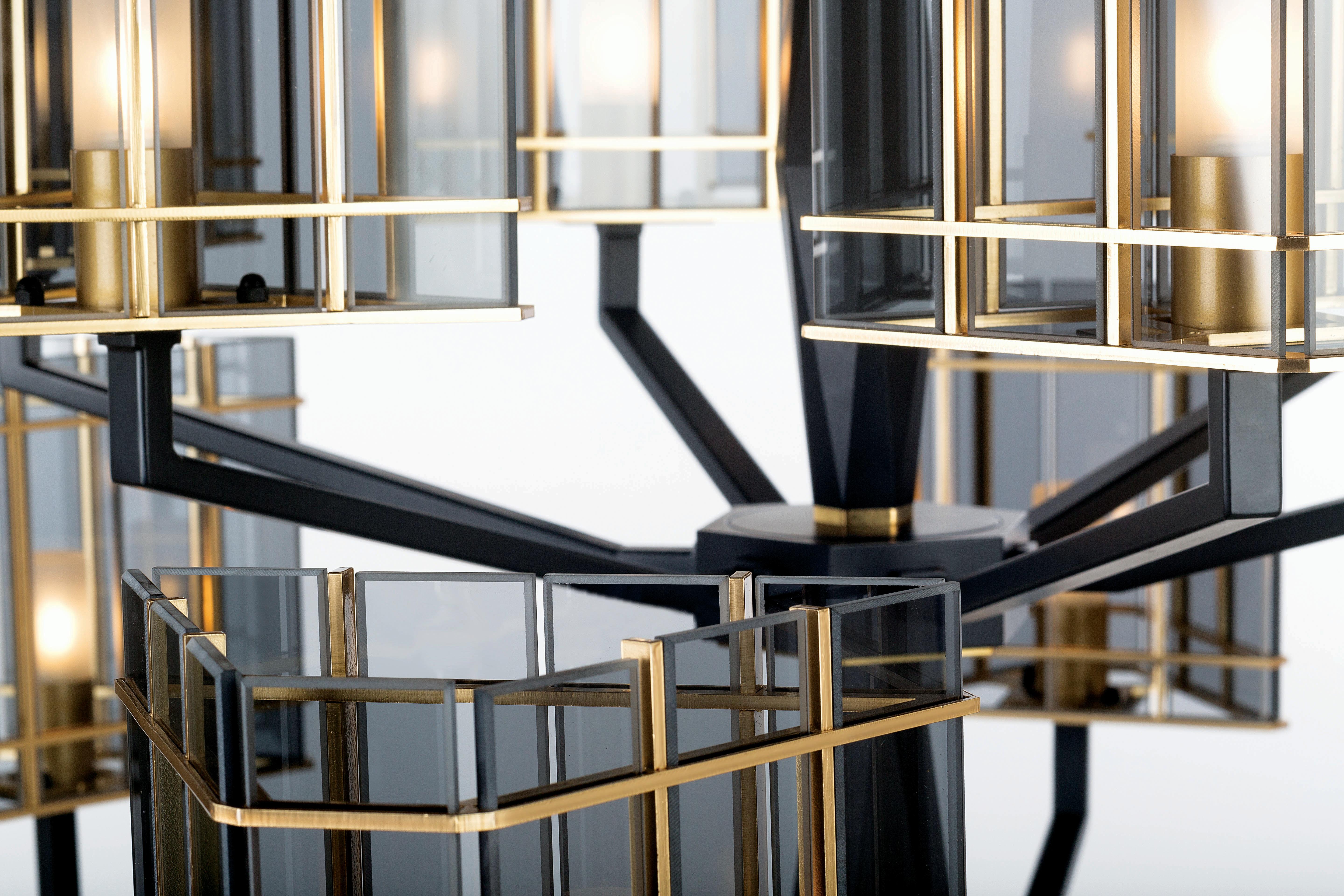 Top Glass Kollektion, eine raffinierte Linie, bei der die mattschwarze Oberfläche Geometrien auf der massiven, facettierten Struktur bildet und die Schirme aus Glaselementen in goldenen Käfigen bestehen. 

Schirme aus transparentem Glas in der