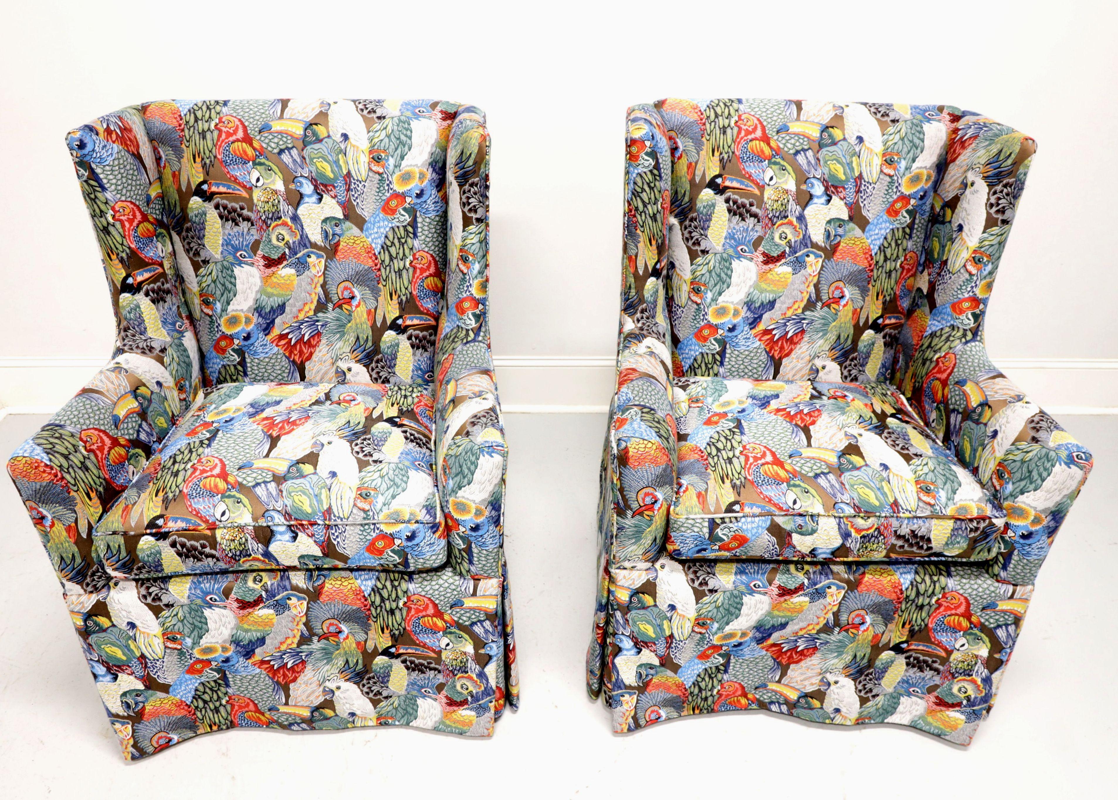 A pair of Traditional style club chairs, unbranded, similar quality to Drexel. Solid wood frame, fully upholstered in a vibrant multi-color bird themed pattern fabric, on straight black painted legs covered by full skirting. Likely made in the USA,