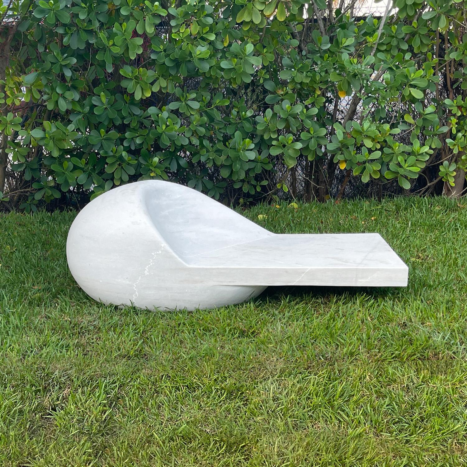 Ce banc de jardin ou sculpture décorative présente un design moderne distingué et est sculpté à la main dans un seul bloc de marbre blanc avec de fines veines grises. L'extraordinaire design sculptural reflète le summum de la beauté intemporelle. Le