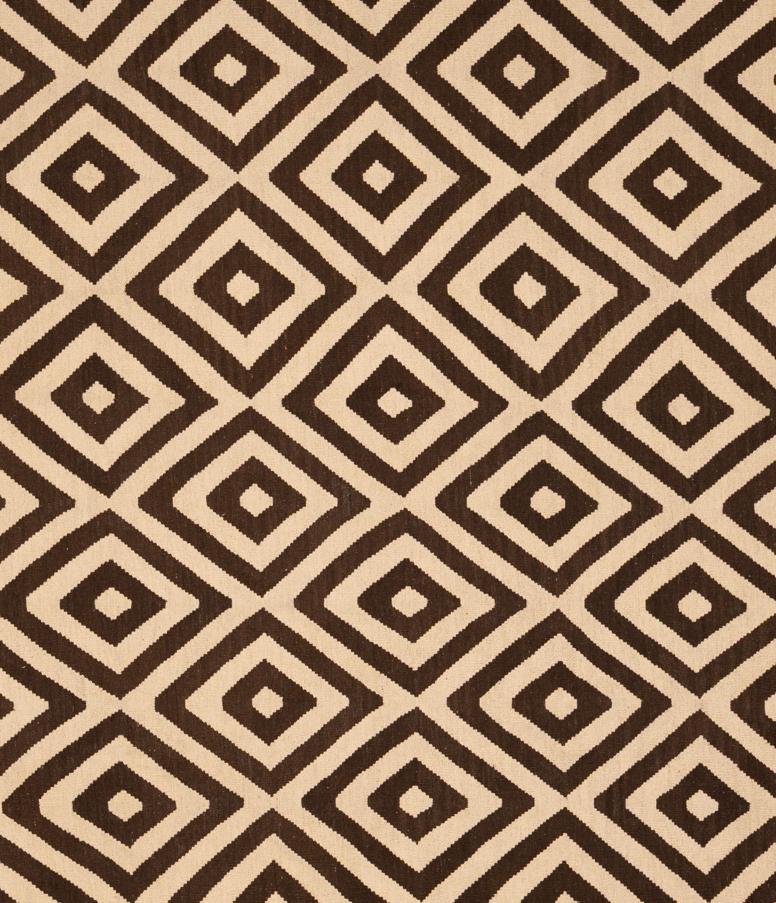 Ce tissage plat tribal de l'Inde est tissé à la main en pure laine et présente une interprétation audacieuse et contemporaine des motifs géométriques traditionnels. Le motif répétitif du diamant, rendu en brun expresso profond et en beige chaud,
