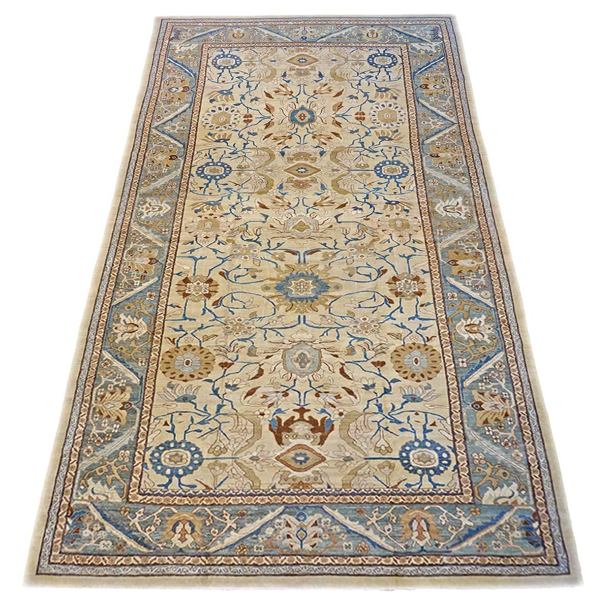 Ashly Fine Rugs presents an antique recreation of an original Persian Sultanabad 13x20 Ivory, Blue, & Gold Handmade Area Rug. Part of our own previous production, this antique recreation was thought of and created in-house and 100% handmade in