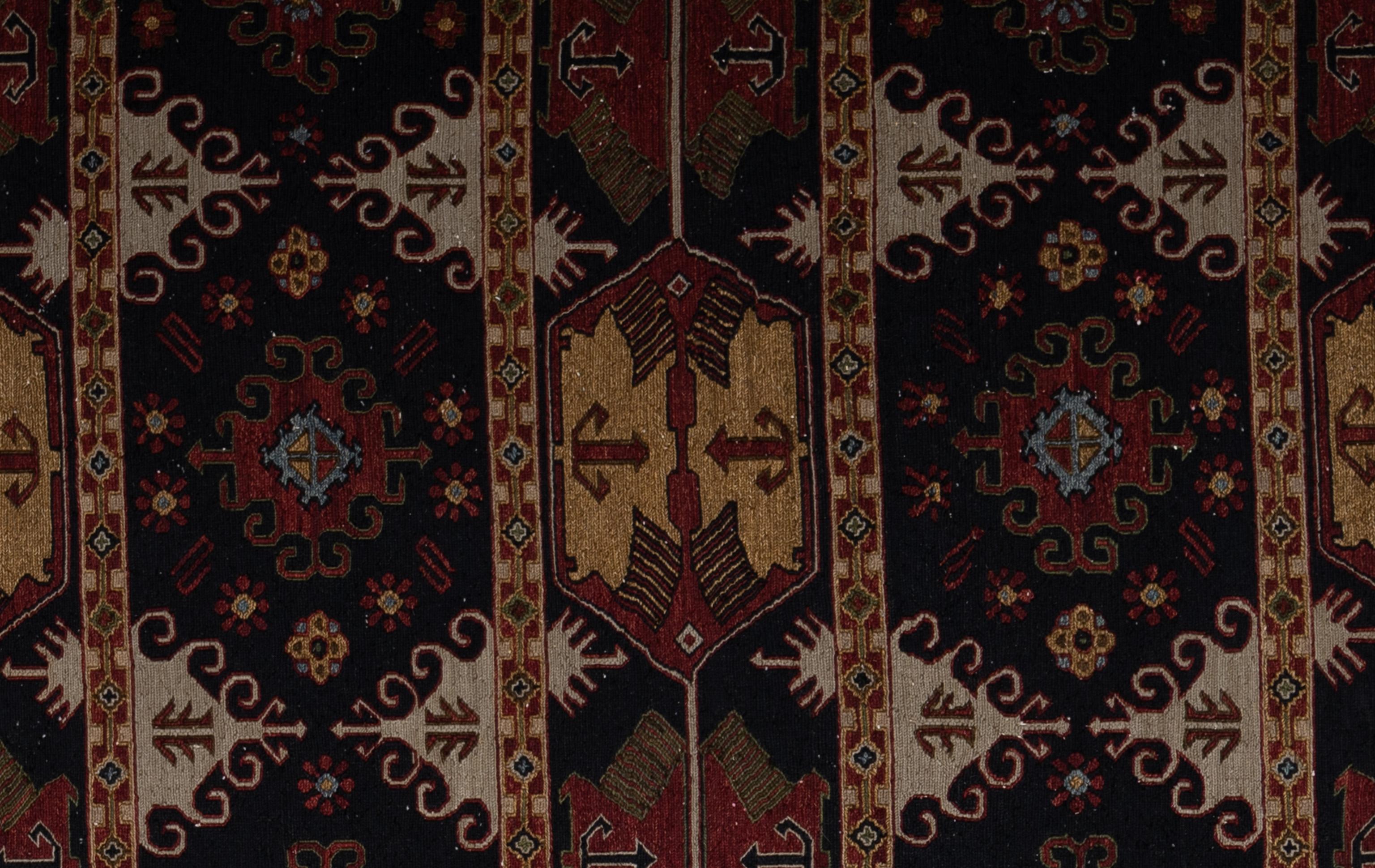 Ce tapis de style ouzbek tissé à la main en Inde présente un design tribal audacieux et complexe, caractérisé par de riches tons de rouge, d'or, de crème et de bleu sourd. La présentation comporte trois panneaux verticaux proéminents, chacun orné de