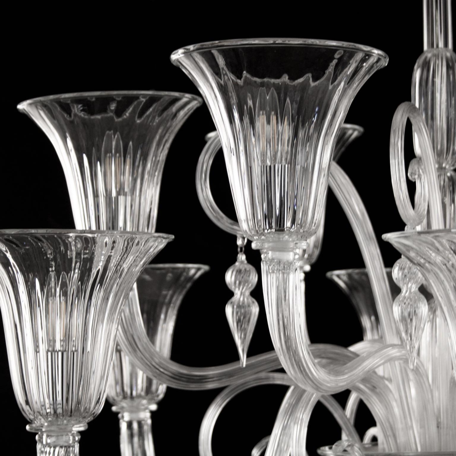 Lustre vénitien 12 bras en verre de Murano transparent, Multiforme
Ce lustre vénitien en verre de Murano transparent se caractérise par une forme romantique et délicate. 
La cuvette inférieure recueille tous les éléments du lustre, bras et détails.