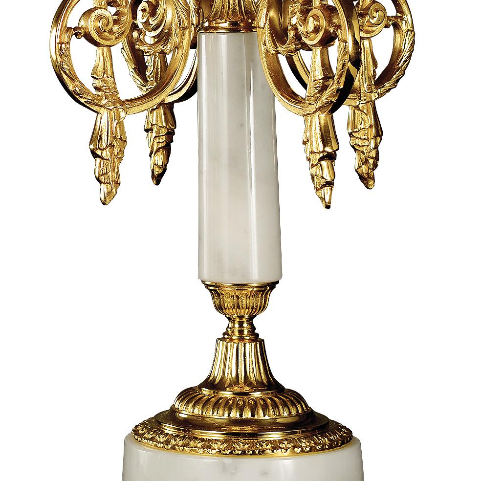Chandelier du XXIe siècle en marbre blanc veiné et bronze doré. Ce candélabre est finement ciselé à la cire perdue. Ce candélabre comporte 5 flammes. Sur demande, le client peut modifier la couleur du marbre : rose, vert et etc... et nous pouvons