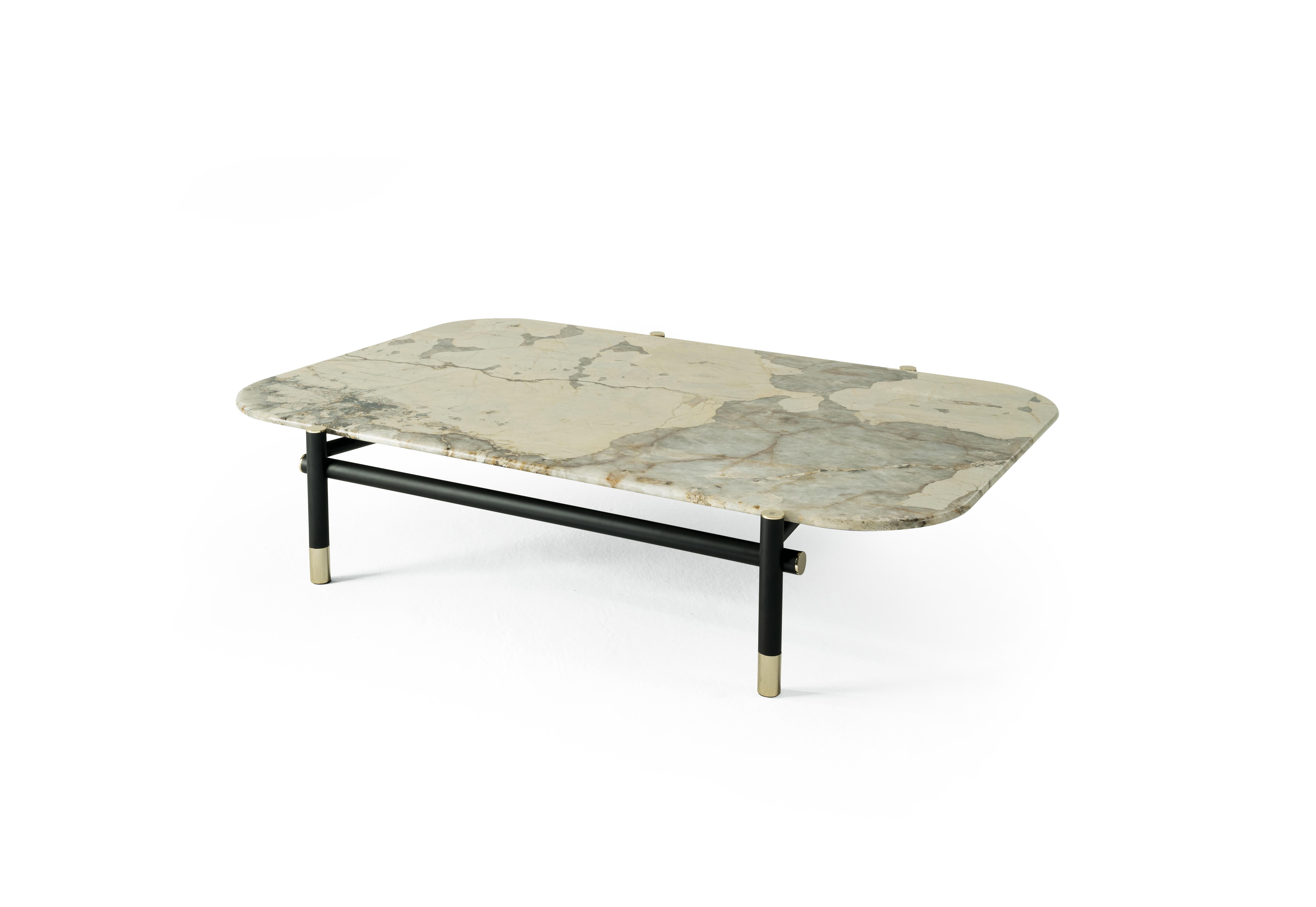 A central table with a precious appeal, Woodstock features a special top in marble enhanced by refined details such as the brass tips of the base. The table is a perfect expression of the extraordinary craftmanship that characterizes the entire
