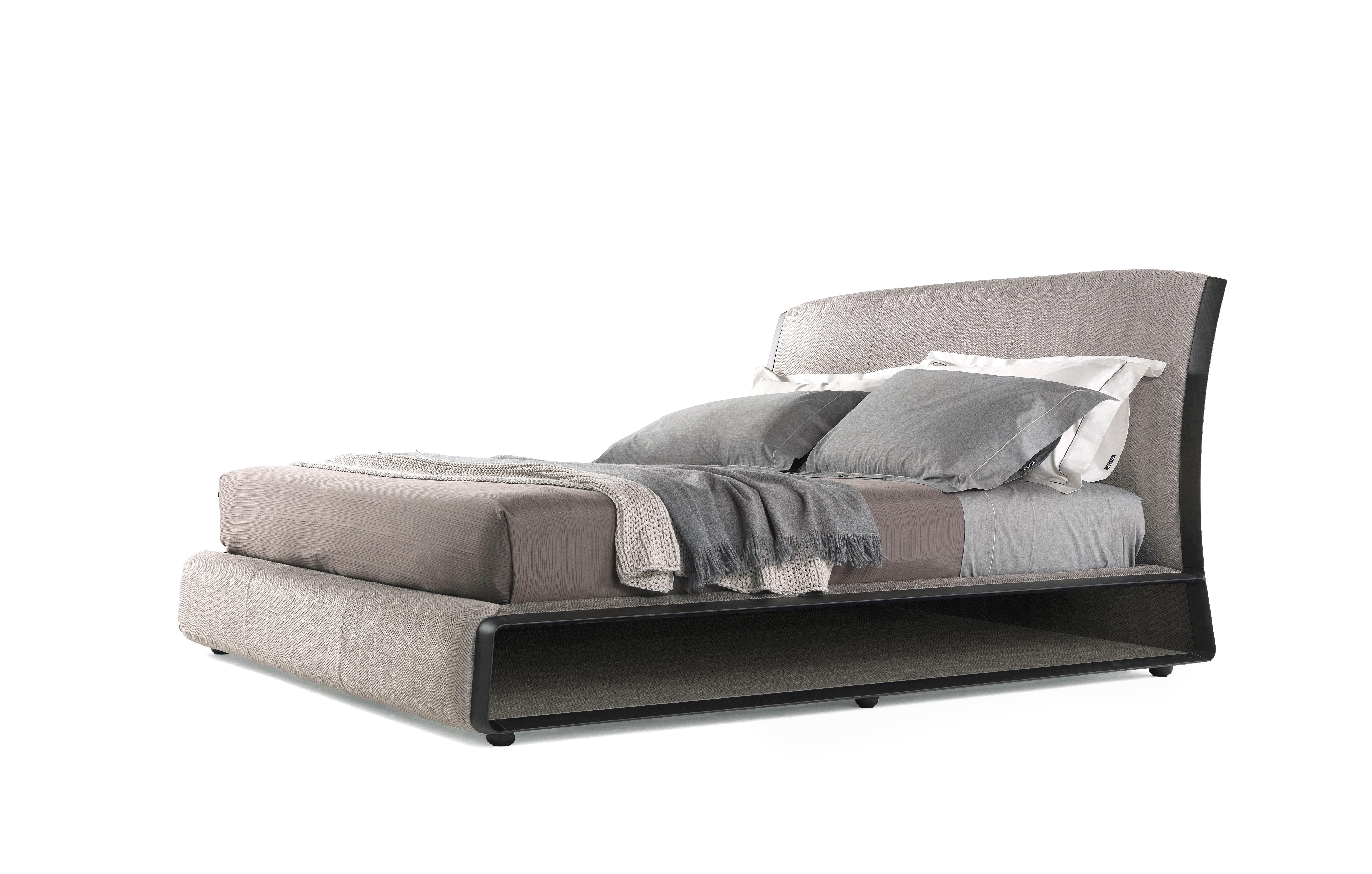 Das Bett Wynwood ist ein geschwungenes und zugleich solides Möbelstück mit kompaktem Volumen, das dank seines raffinierten und durchdachten Designs Komfort und Ästhetik miteinander verbindet. Das Kopfteil ist mit einem grauen Fischgrätstoff bezogen,