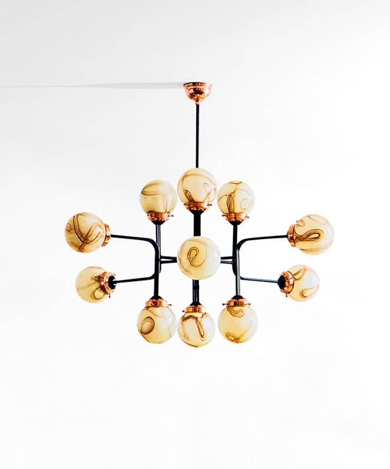 Ziron is an entirely handmade chandelier inspired by antique handblown glasses, which are not produced anymore. Each handblown glass dome is unique with different patterns but harmonize with each other in an elegant way. Black painted metal pieces