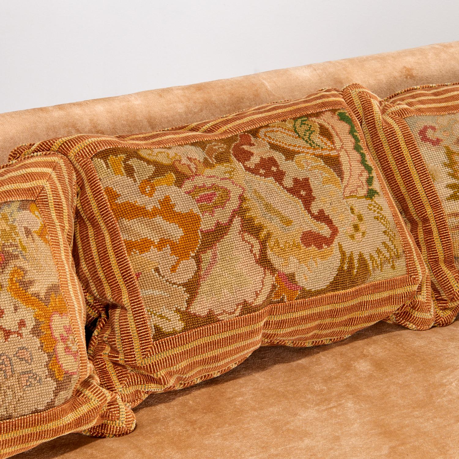21st c., USA, fully upholstered in mohair velvet with matching bolster pillow sides and four antique needlepoint back cushions, pleated skirt over inset wood legs.

A luxurious upholstered sofa covered in Brunschwig & Fils mohair velvet in the color