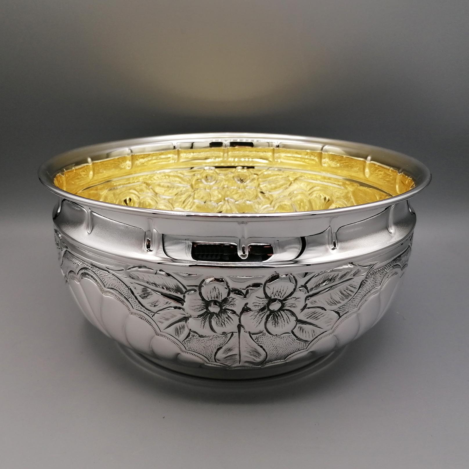 Centerpiece bowl in 800 solid silver.
The bowl is round and pot-bellied with only a groove in the upper part. Embossments and chisels have been executed all over the body.
Curved lines interspersed with flowers and leaves have been chiseled.
A