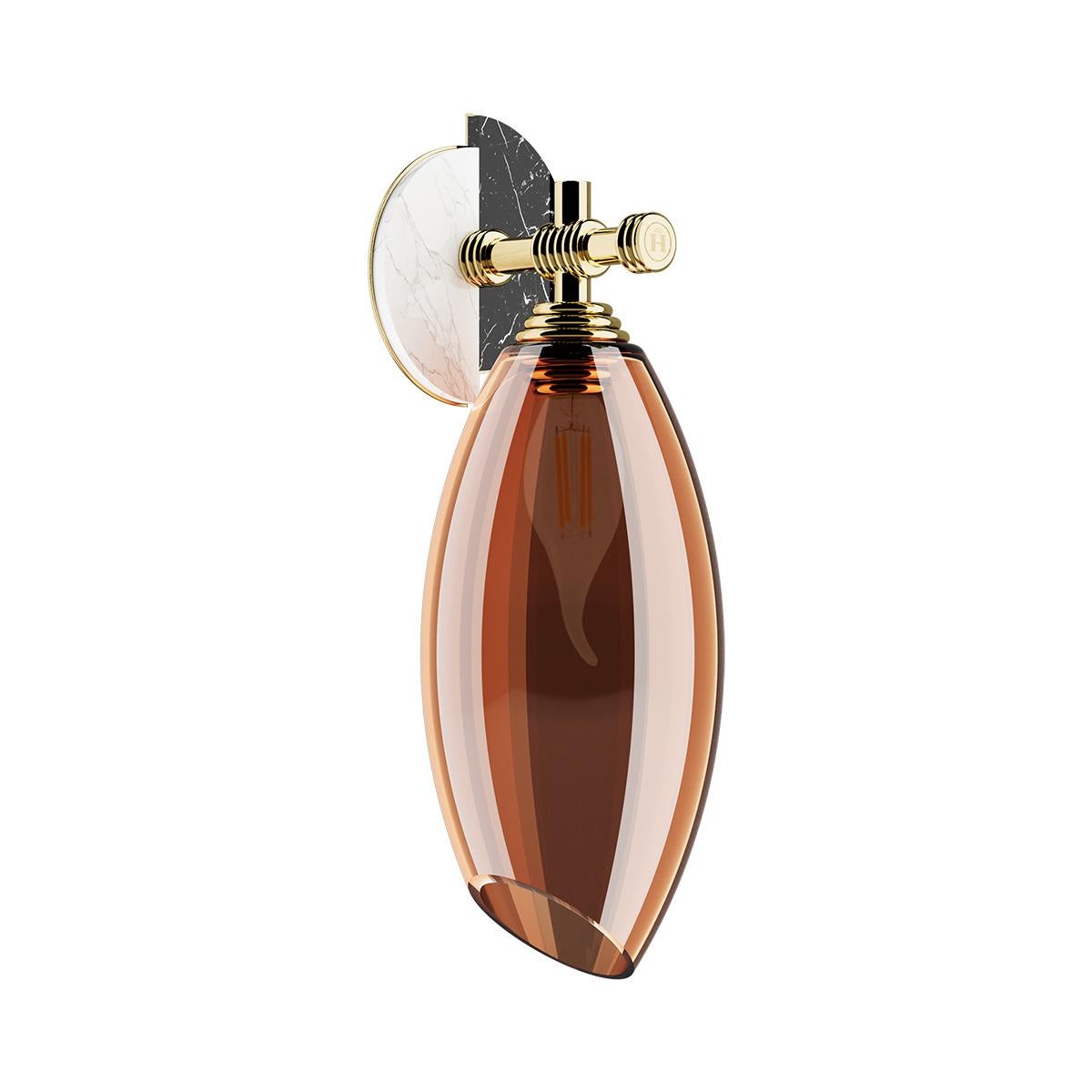 Cocoon Sconce was inspired by the shapes of Art Deco jewels. A modern sconce designed to bring elegance and character to any living area. A luxury wall lamp for a high-end interior design project.

Materials: Structure in Polished Brass; Amber