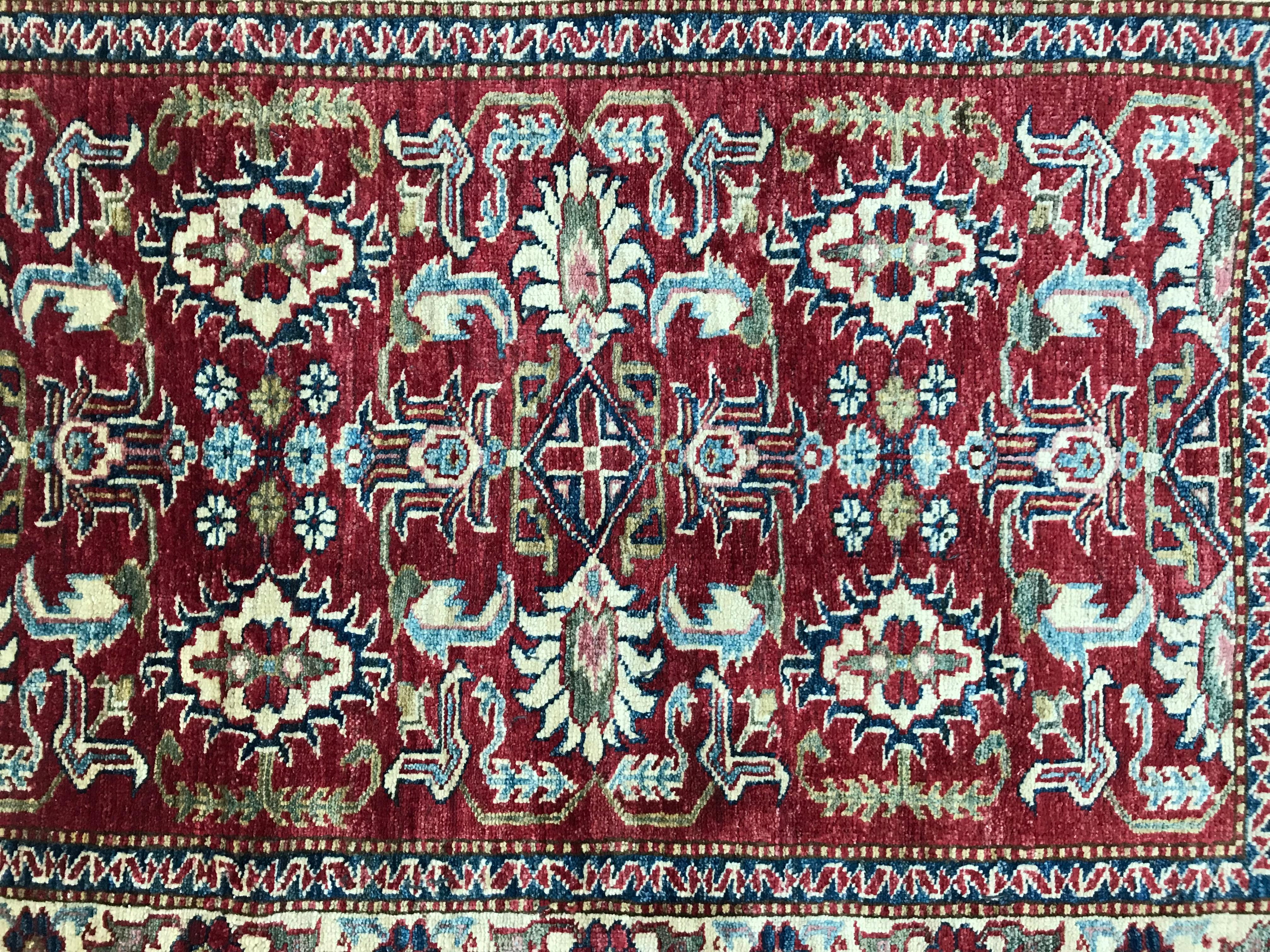 Petit tapis afghan avec un joli dessin géométrique et des couleurs et motifs, entièrement noué à la main avec du velours de laine sur une base de coton.