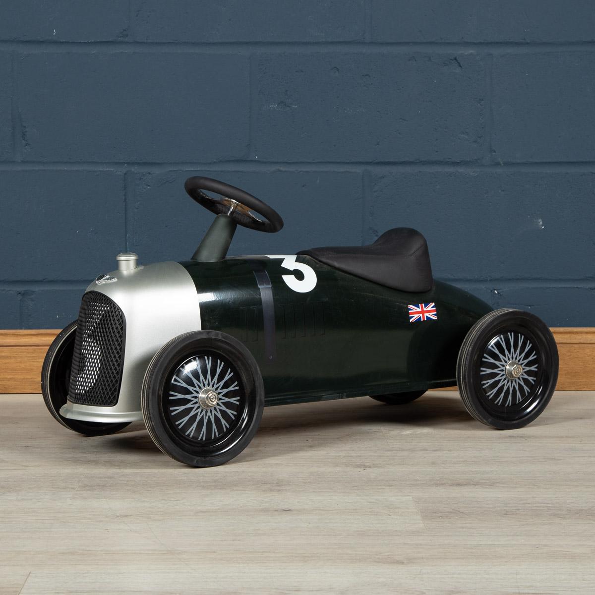 A superb child’s toy car of metal construction, aerodynamic design, deep green racing colour, chrome grill, Bentley logo, black leather seat and steering wheel, large wheels with real rubber tyres. Beautiful little gift or just as a piece of artwork