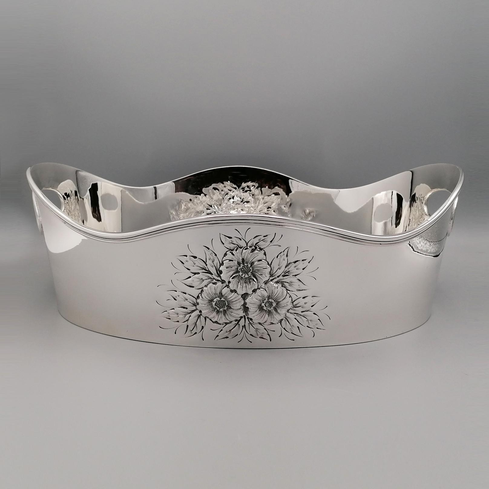 Oval centerpiece in sterling silver made entirely by hand.
The centerpiece is wave-shaped and finished on the upper part with an English-style border, which also surrounds the oval holes on the short sides, made to facilitate grip.
On the long parts