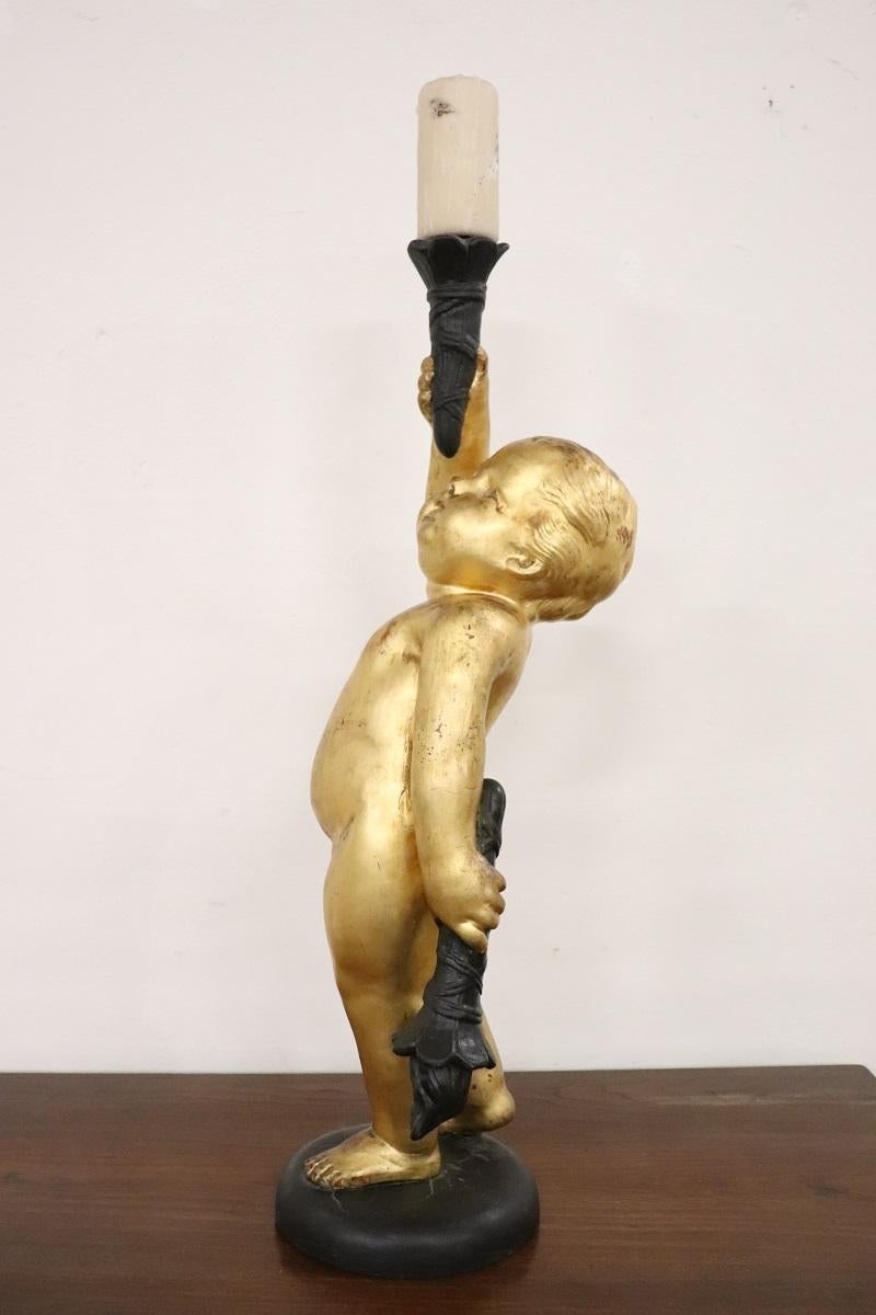 Bougeoir italien raffiné en matériau composite de fabrication récente. Un magnifique chérubin doré avec une base ronde en bois. Élément décoratif particulier pour la maison. Des conditions parfaites.
