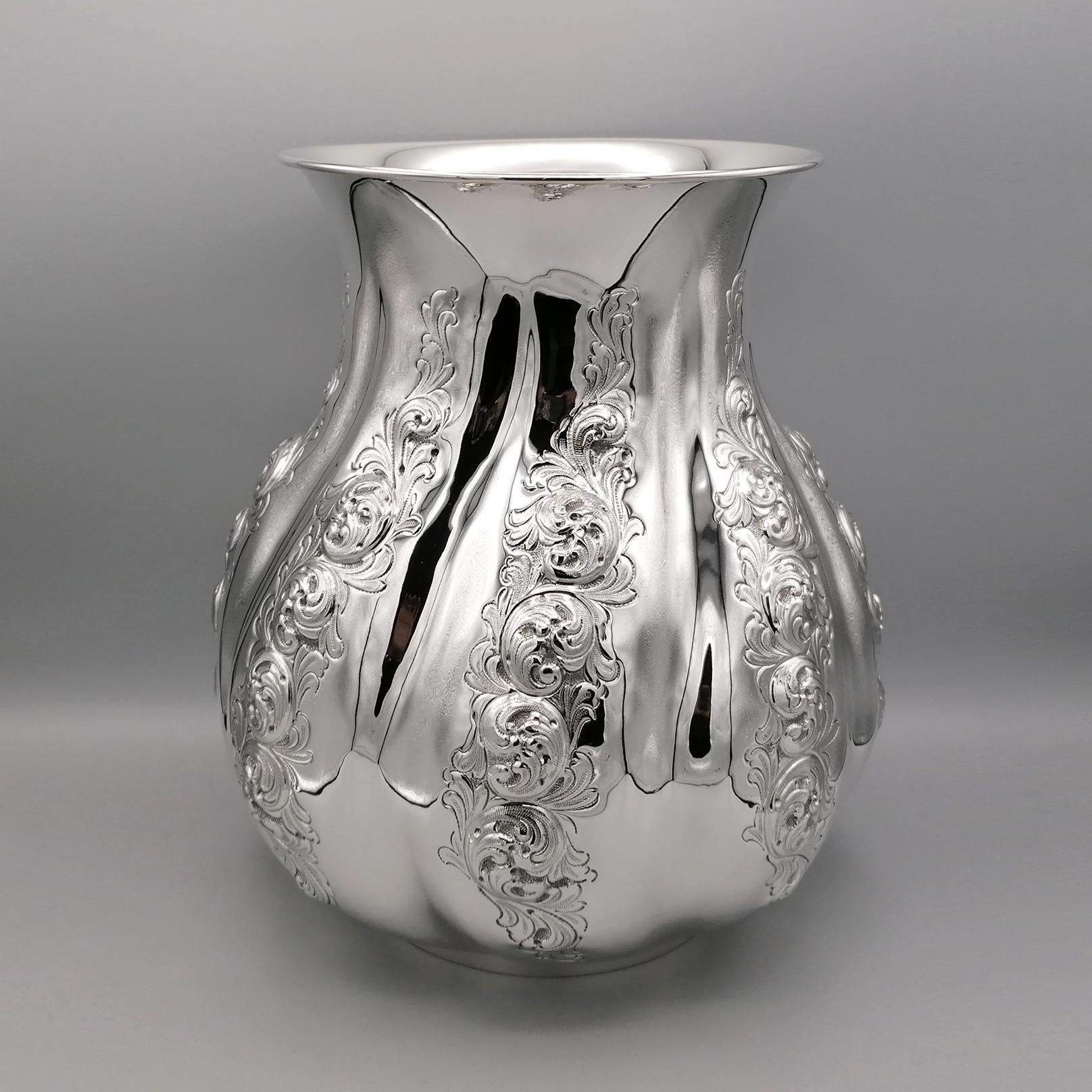 Italian vase from the 21st century. The body of the vase is round, pot-bellied and worked with the embossed and chisel technique.
The volute design, typical of the Italian Baroque, has been embossed on torchon grooves making the structure of the