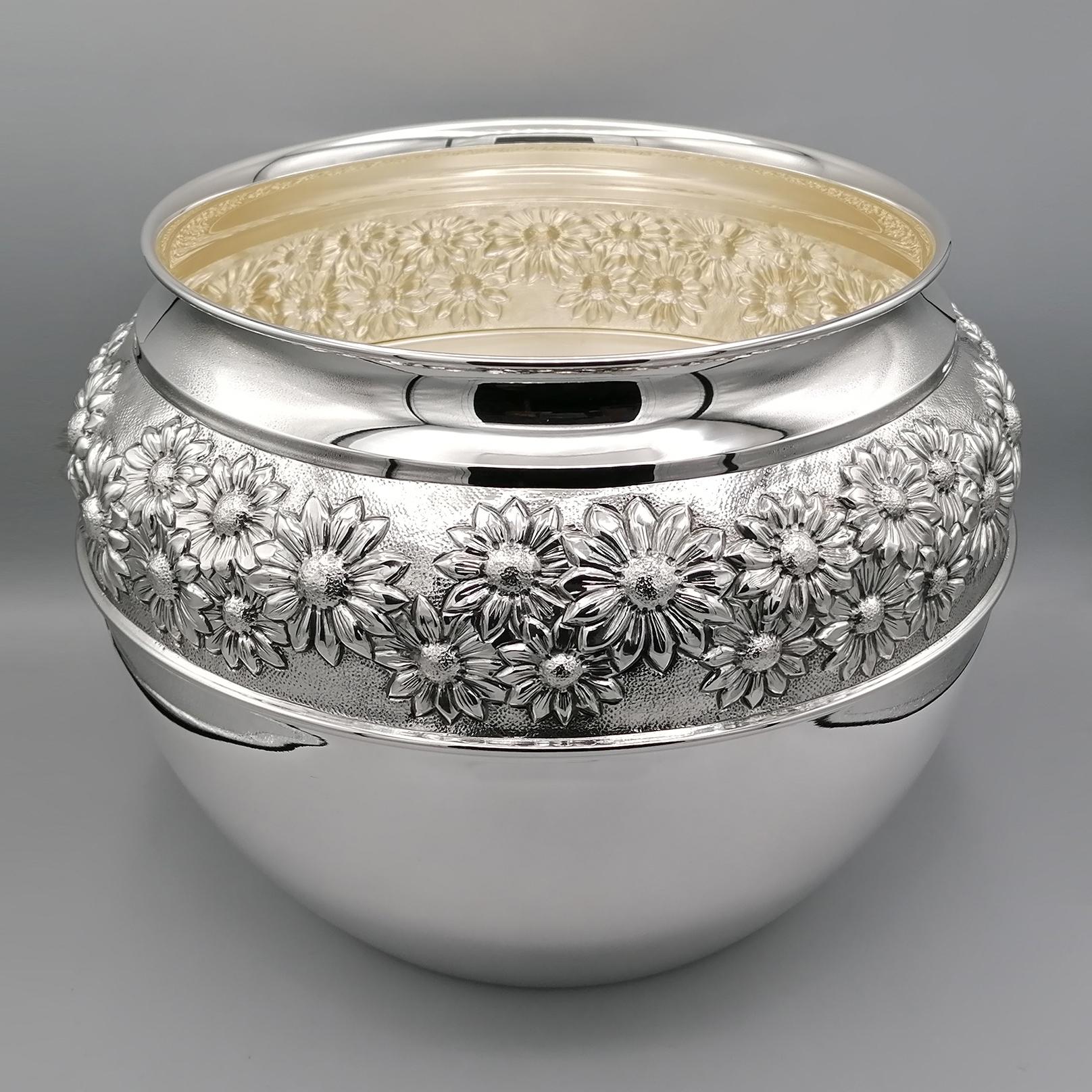 Gorgeous sterling silver centerpiece.
The body shape is round and smooth decorated with an embossed and chiseled band with flower motifs.
In the spaces between one flower and another, knurling has been made to make the flowers stand out.
The