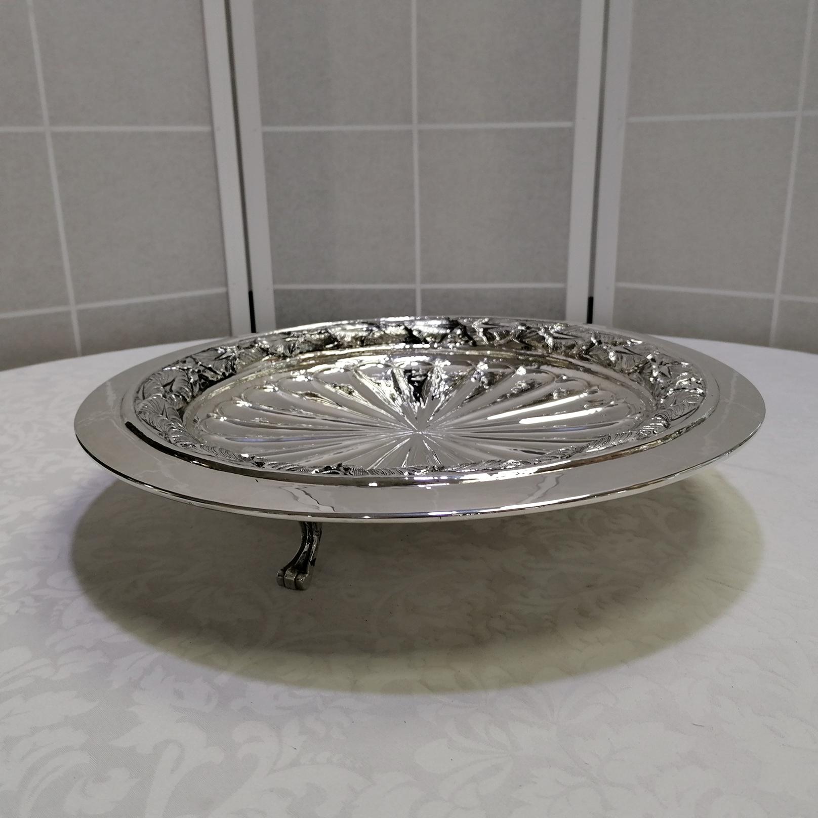 Large round centerpiece in sterling silver.
The centerpiece plate was made in the Empire style, without using borders but embossing and chiseling the ancanthus leaves inside the external band.
The outermost part of the centerpiece has been left