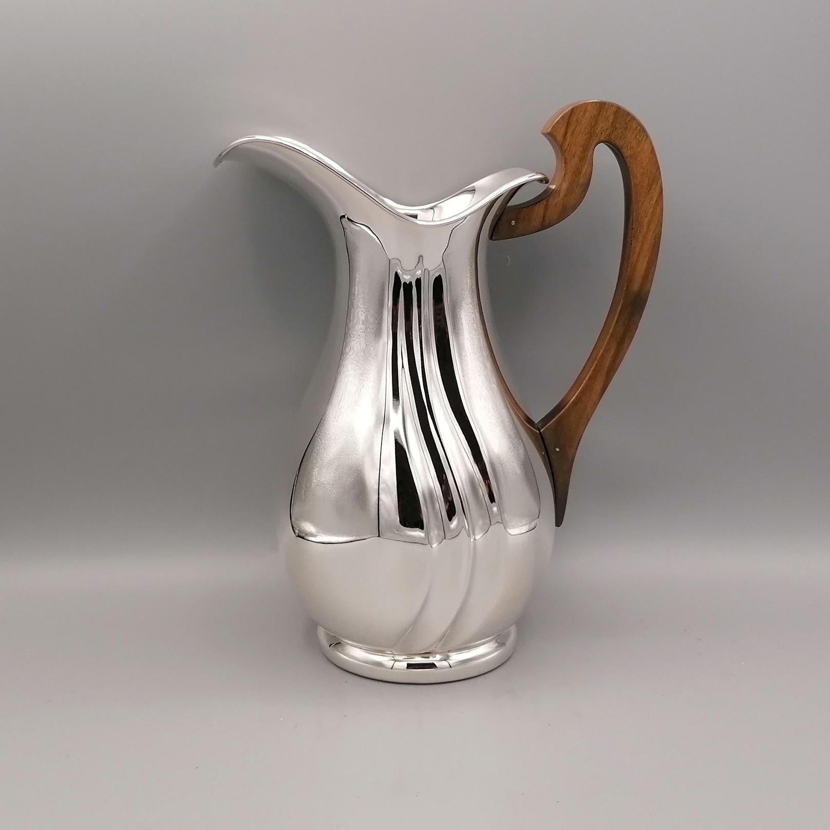 Completely handmade sterling silver water jug.
The body is completely smooth with two torchon grooves which make the object very bright and elegant.
The pourer is large and concave, to allow a precise flow of water.
The handle, designed for a