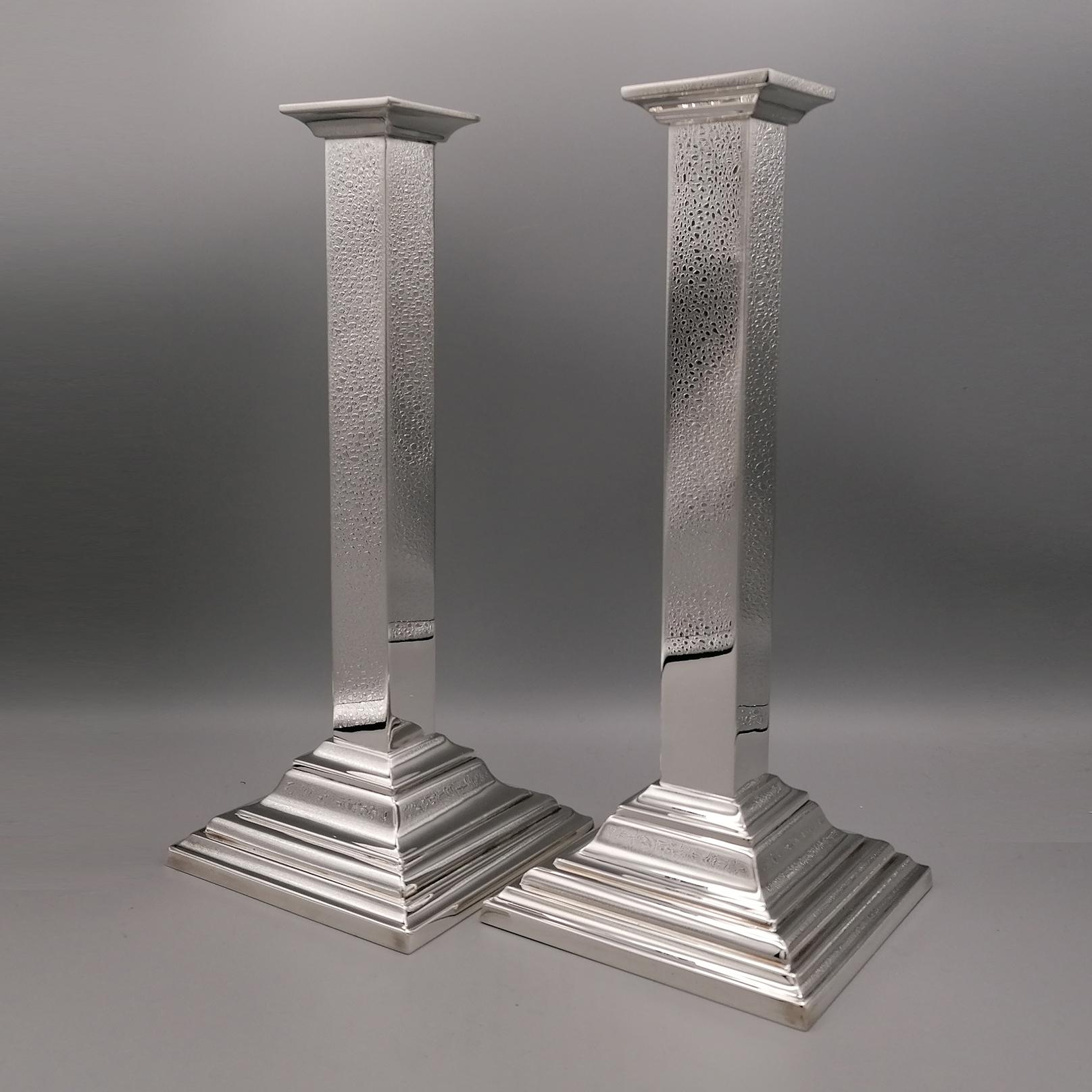 Pareja de candelabros de plata de ley totalmente hechos a mano en un estilo moderno. La base es cuadrada con escalones, mientras que el tallo, también cuadrado, es completamente liso con la parte superior que se ensancha ligeramente para alojar el