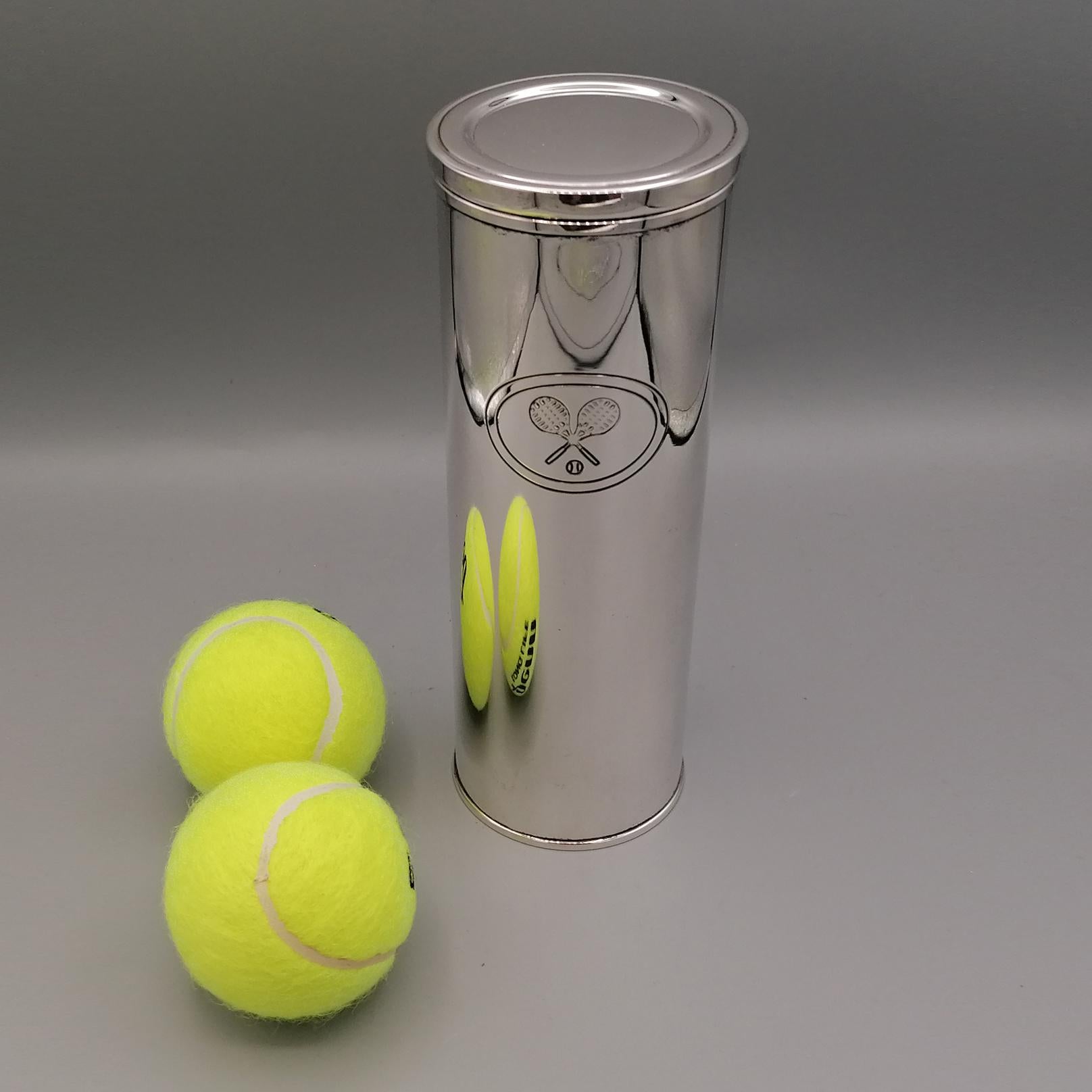 Sterling silver tennis ball holder smooth 925 sterling silver ball holder tube, featuring an engraved oval with 2 rackets and balls. The lid is smooth with a lowered central part. This rib makes it very robust to allow it to be opened and closed