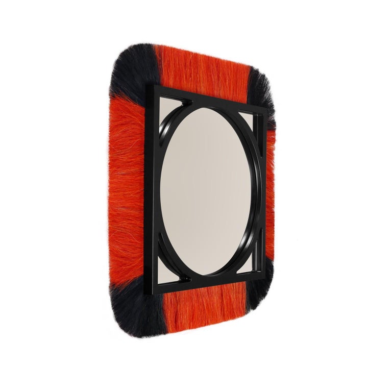 Moritz is a luxury wall mirror inspired by the raw and timeless textures of the tribes' decorations, jewels, and artistic elements. This decorative mirror is made of lacquered wood in the structure and ornamented with vibrant colored fiber. Moritz's