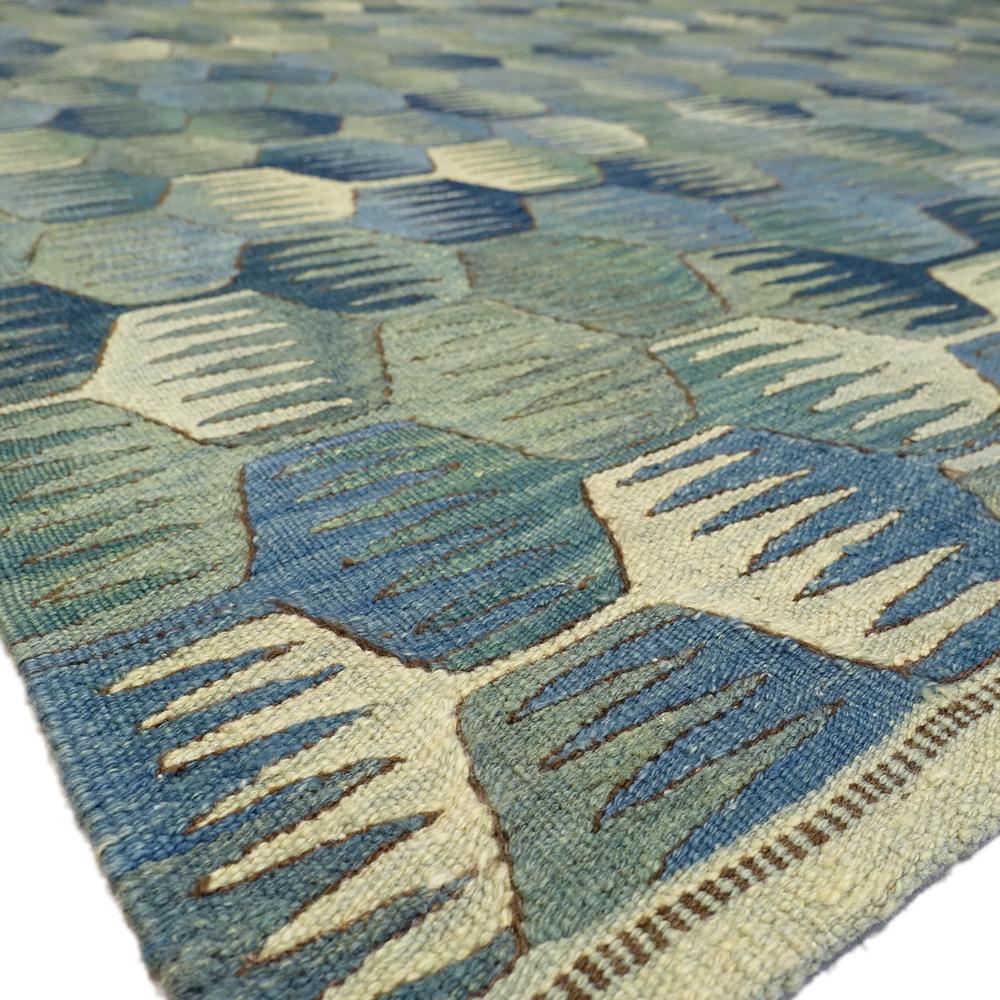 21st century modern handspun handwoven Anatolian Kilim carpet.

Wonderfully graphic and suitable for many modern furnishing styles. The kilim fits through its floral green tones and yet abstract pattern to many furnishings and enlivens any room.