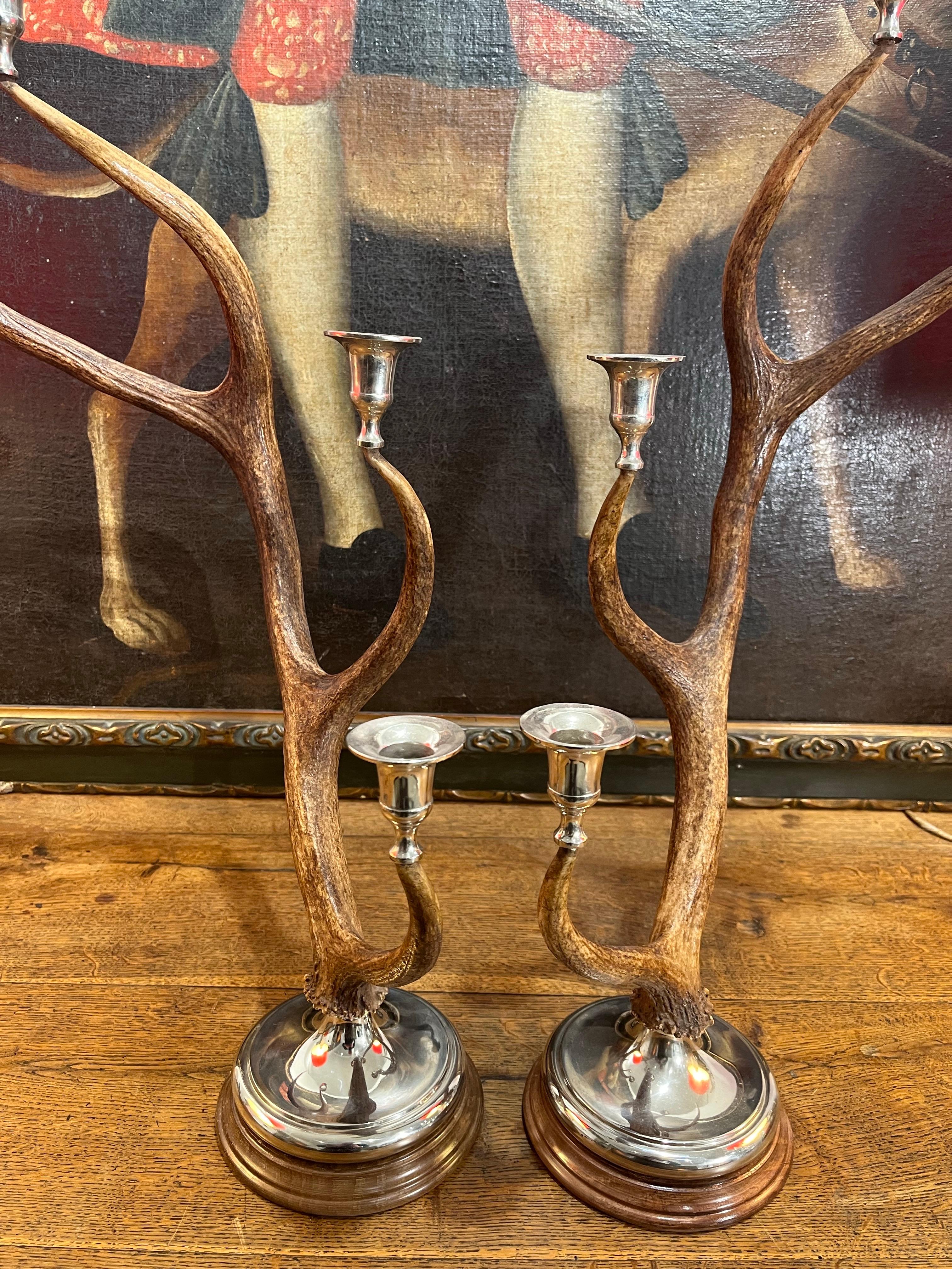 Handcrafted candlesticks made in Spain from deer antlers. Each candlestick has three nickel-plated metal candle holders. The antlers are supported by a wooden base and a silver-plated metal platform. We have more units available.