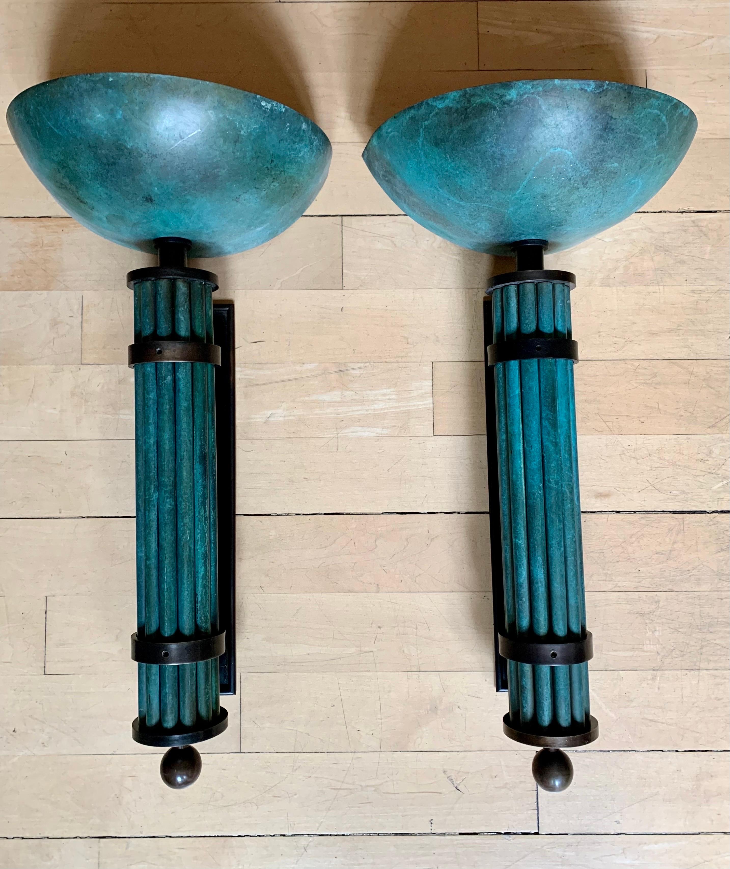 A pair of large wall sconces in Art Deco style, made entirely of bronze, with two techniques, oil-patinated bronze and oxidized-effect bronze, the sconces are supported on a patinated bronze support, in which the sconces are hooked. These are made