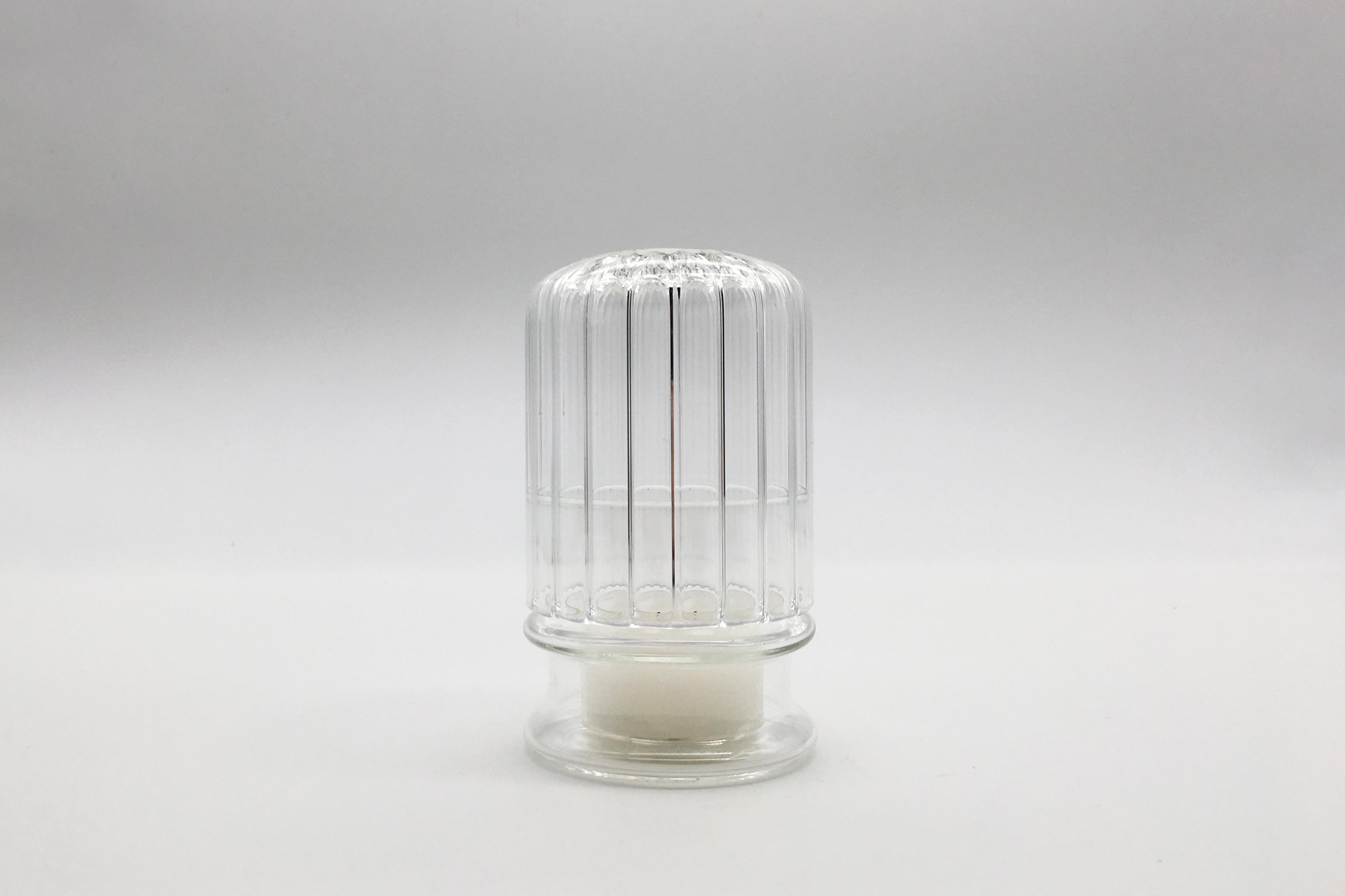 Moscardino is an elegant candle holder handcrafted in borosilicate glass by Venetian craftsmen. The structure of this decorative element appears as a dome that protects and accommodates a small candle. The faint light from the candle fire creates a