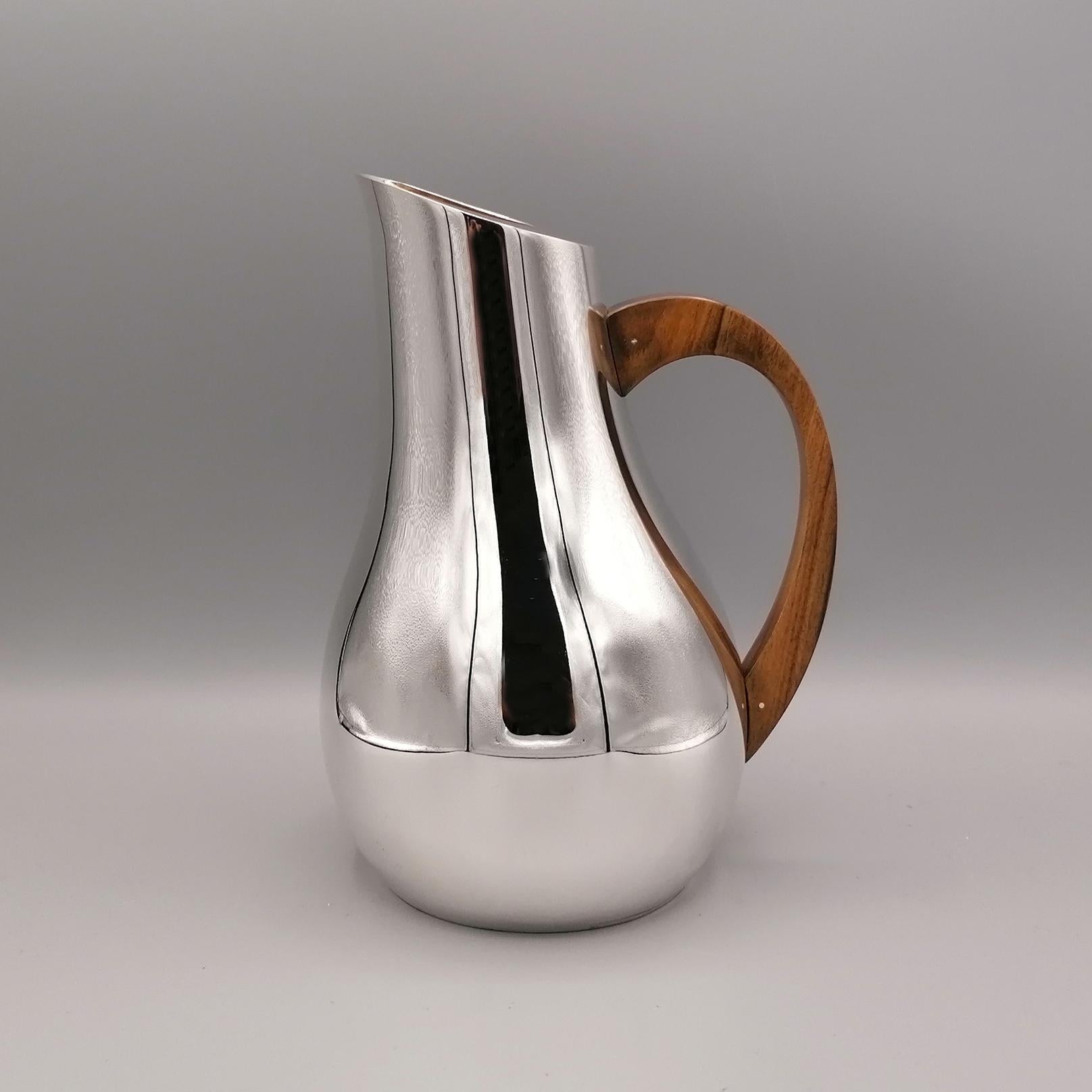 Solid sterling silver water carafe. 
The body is round and has been completely handmade starting from a flat silver sheet and subsequently modeled to give the object a round and slender shape, in the shape of a pear.
The carafe handle was also