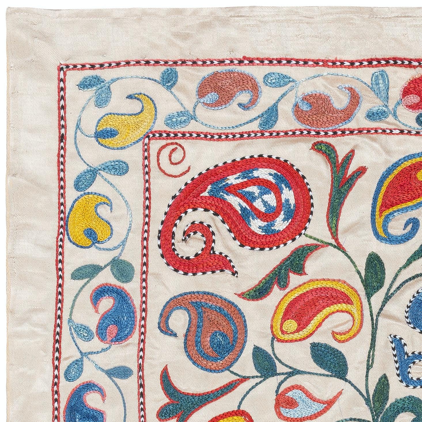 Zelebrieren Sie das reiche Erbe asiatischer Handwerkskunst mit diesem exquisiten Suzani-Textil aus 100 % Seide, das von erfahrenen Kunsthandwerkern sorgfältig von Hand bestickt wird. Dieses wahre Kunstwerk verkörpert eine jahrhundertealte Tradition