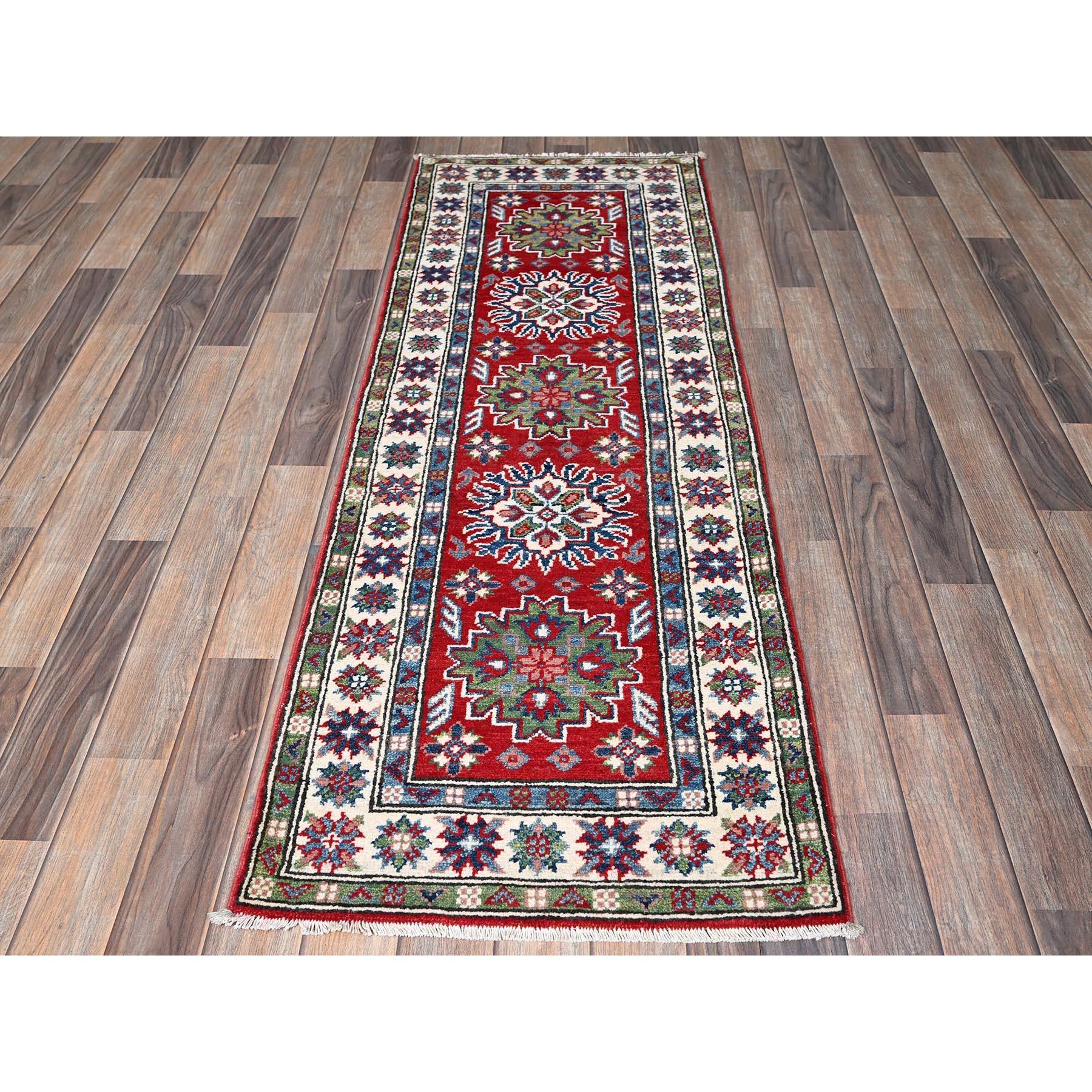 Rouge cramoisi, Kazak avec motifs de médaillons tribaux, noué à la main, teintures végétales, laine douce et brillante, tissage plus dense, chemin de fer étroit, tapis d'Orient
Matières premières : Laine
Latex : Pas de poils 
hauteur : 0,25