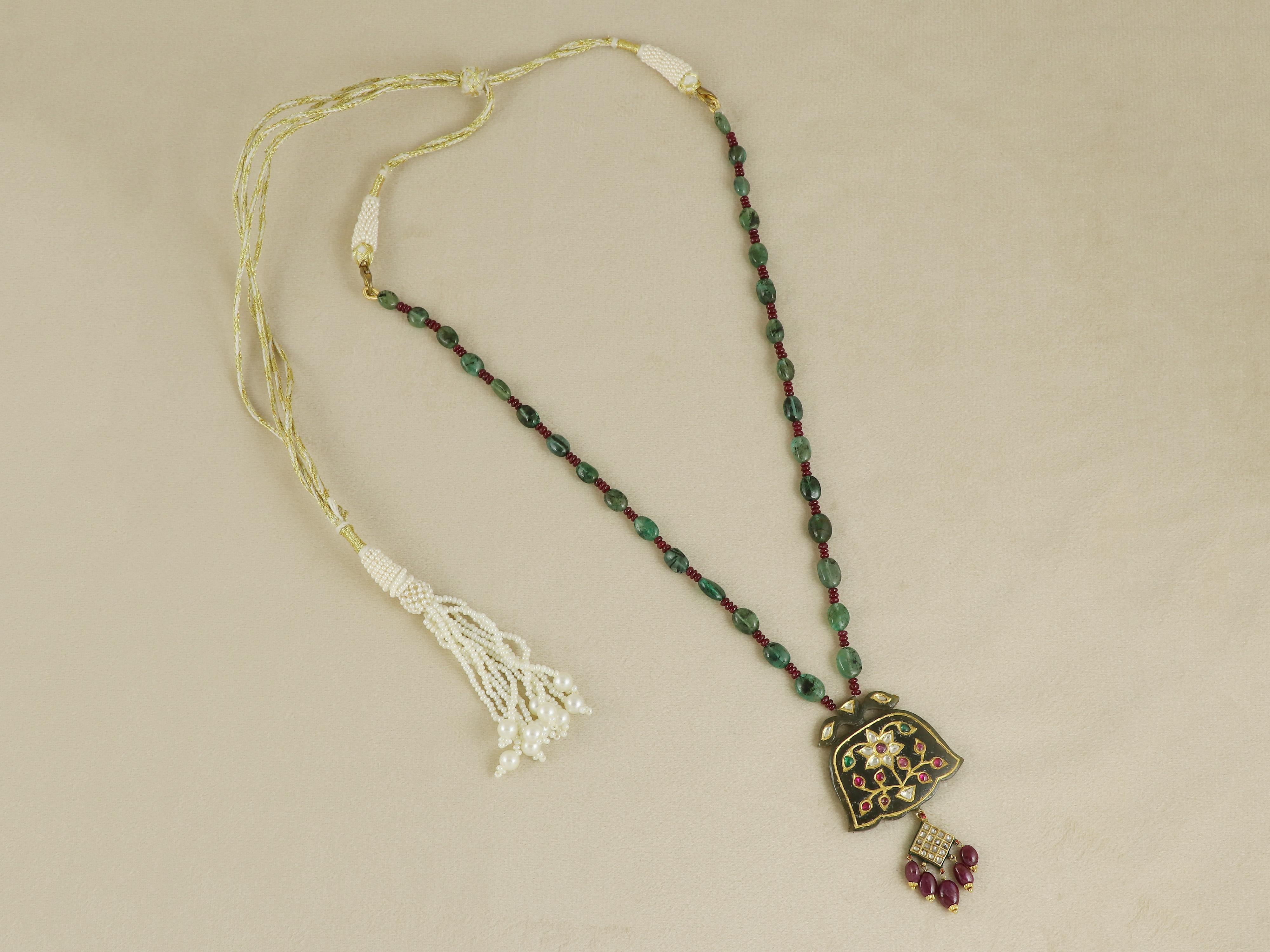 Ispirata alla grandezza dell'arte Mughal, questa eccezionale collana con ciondolo è una testimonianza dell'artigianato tradizionale. Il ciondolo è magistralmente scolpito in un'antica pietra di giada nefrite con un intricato motivo Mughal sul retro,