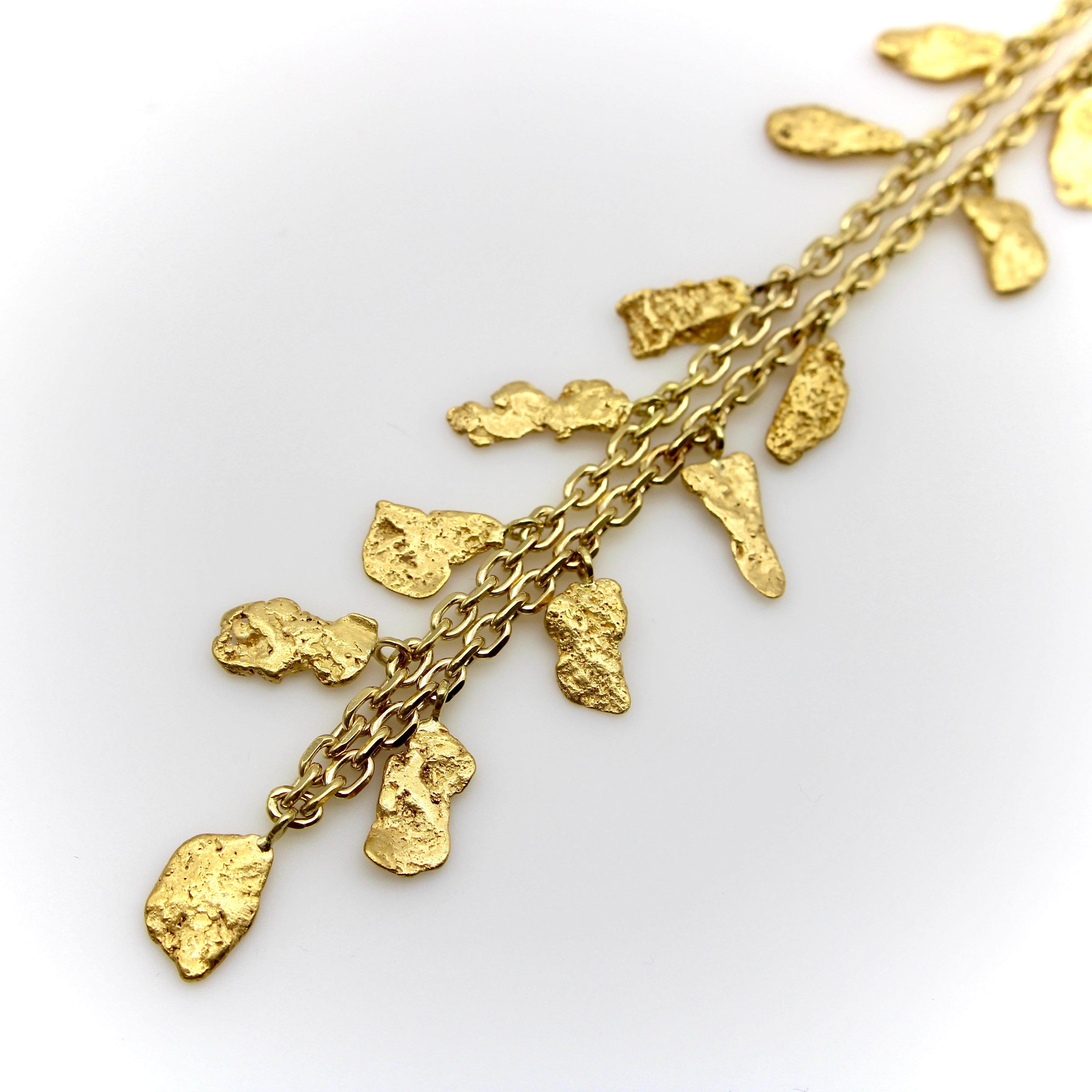 This 18k gold Italian chain contains a selection of stunning 22-24k gold nuggets. The nuggets graduate in size, with the largest nuggets at the center of the chain; each has a unique shape and the variations of sizes and forms complement each other