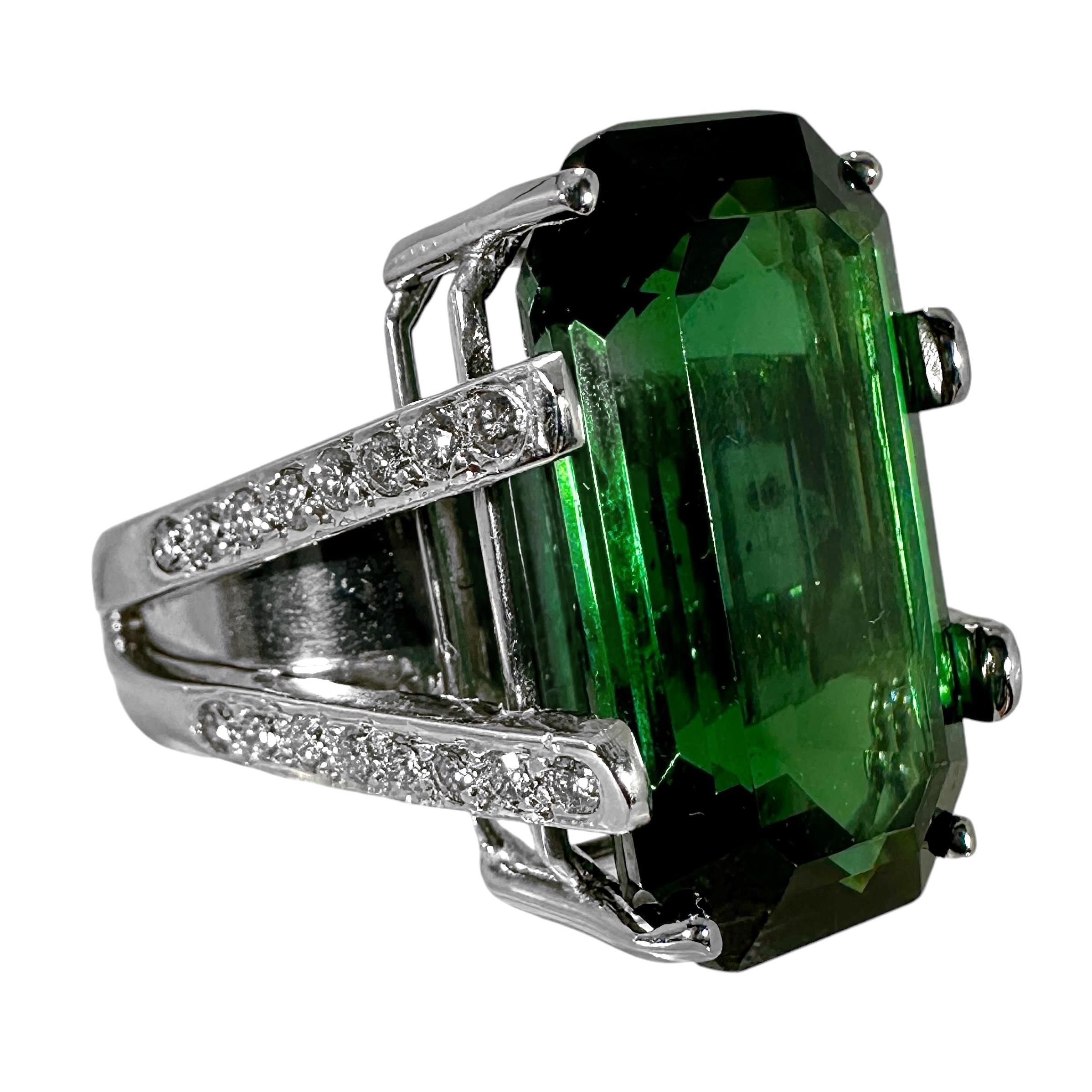 The contrast of the long and sexy dark green center stone set in platinum, against the brilliant white diamond shoulders, makes this ring ideal for wearing with many dark color garments.
The center stone is a beautifully balanced, emerald cut,