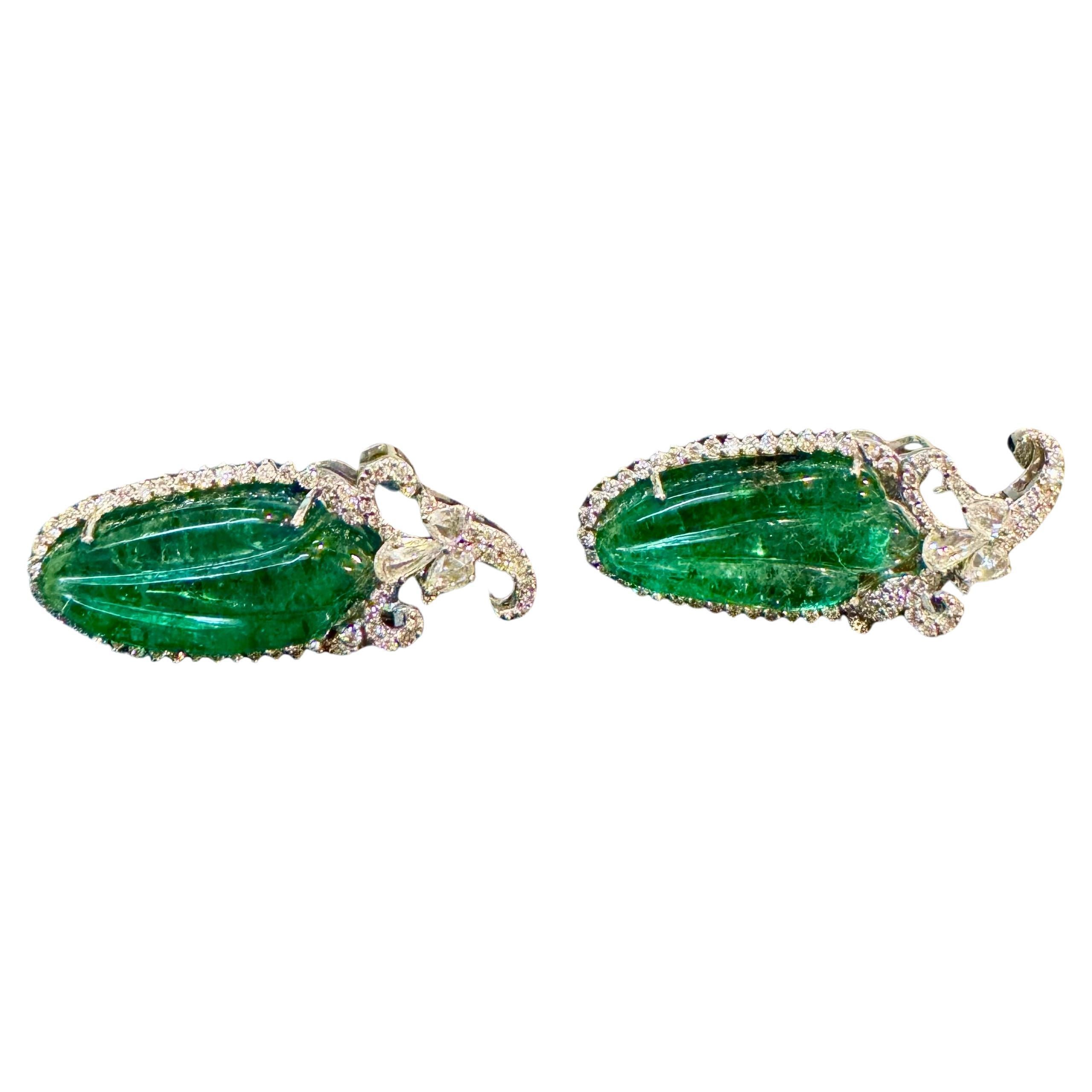 22 Ct Carved Emerald & 2 Ct Diamond Earrings
Emerald Diamond Post Earrings 18 Karat White Gold
Two fine carved leaf emeralds of total 21.90 ct exact known weight. Emeralds are surrounded by Brilliant cut round diamonds. There are three rose cut pear